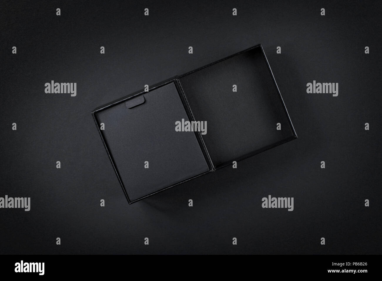 Scatola di cartone nero vista dall'alto su nero. Tasto basso studio shoot Foto Stock