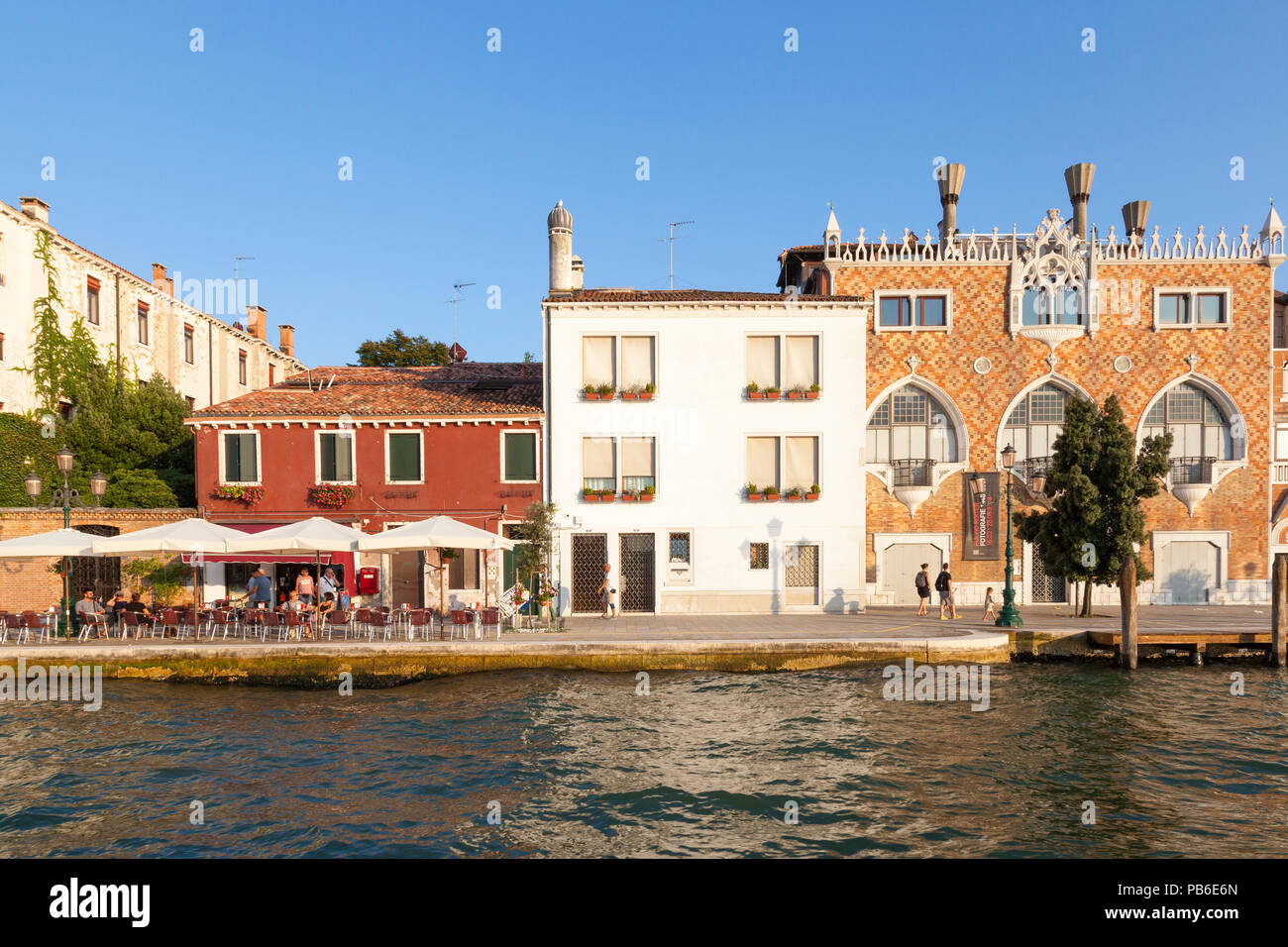 La Fondamenta Zitelle, isola della Giudecca al tramonto, Canale della Giudecca, Venezia, Veneto, Italia con tre Oci Art Gallery e il Bar de Matteo con persone godendo Foto Stock