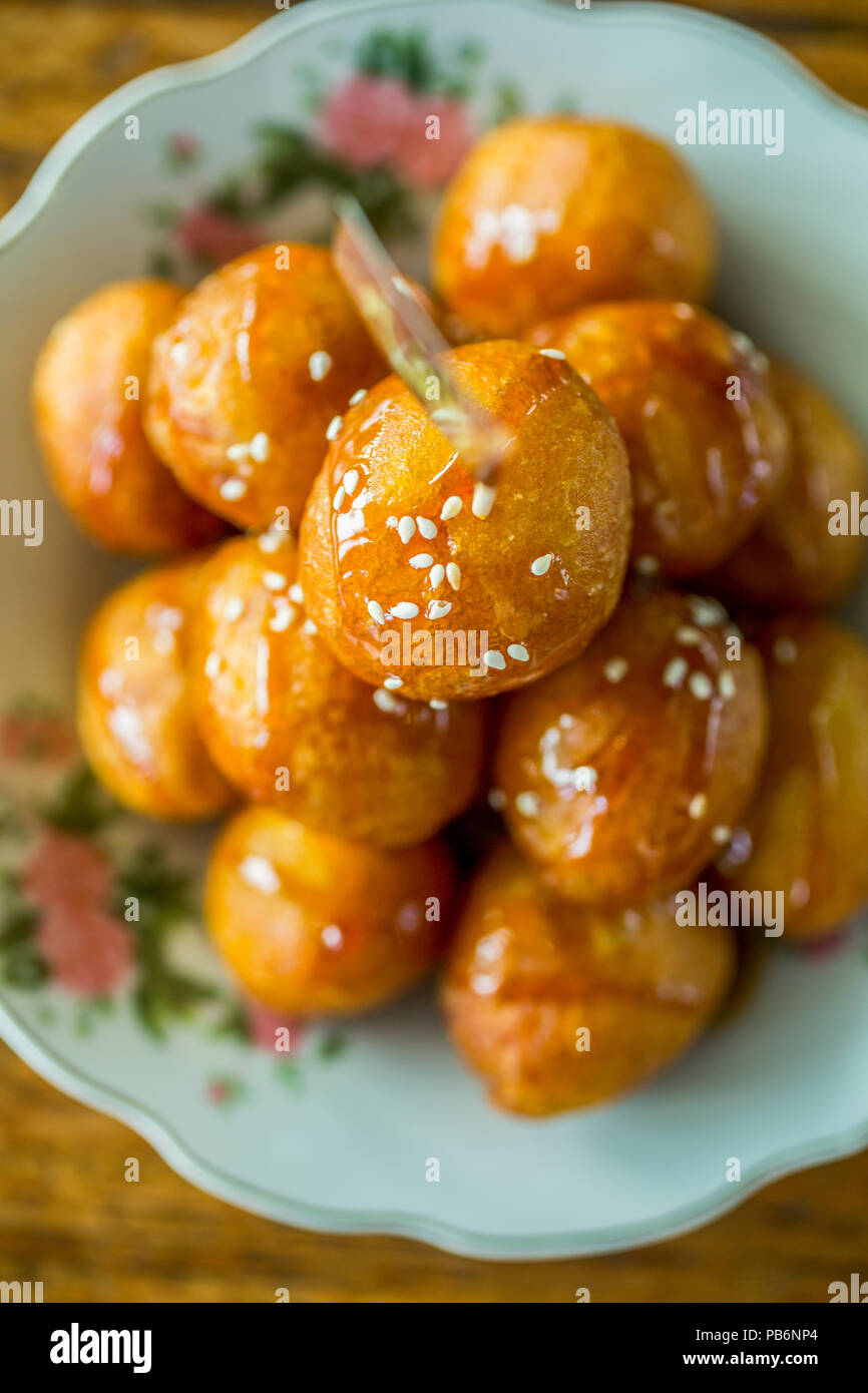 Dolce fritto palline di pasta con miele su una piastra Foto stock - Alamy
