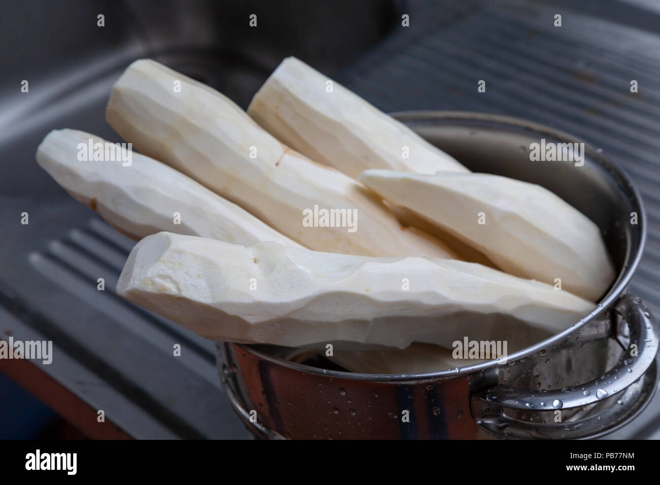 Manioca (Manihot esculenta) (spagnolo: "mandioca", Guarani: mandi'o), radici spellate nel recipiente, sul dissipatore di lavaggio, all'aperto, Asunción, Paraguay Foto Stock