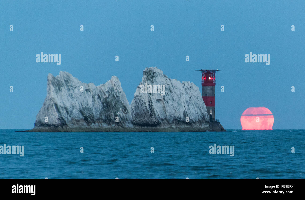 Luna piena impostazione gli aghi faro. Fotografato da allume bay, Isola di Wight. Foto Stock