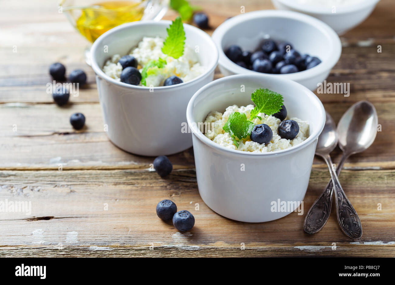 Cottage fresco formaggio con panna acida, mirtilli e miele. Una sana prima colazione Foto Stock