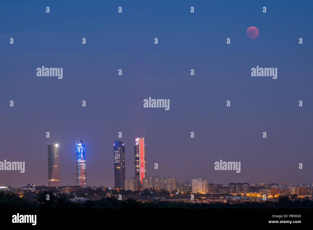 Madrid, Spagna. 27 Luglio, 2018. La luna compare vicino a le quattro torri grattacieli durante un'eclissi lunare totale eclipse, il più lungo del secolo, con una durata di 1 ora e 43 minuti e 35 secondi. A Madrid, Spagna. Credito: Marcos del Mazo/Alamy Live News Foto Stock