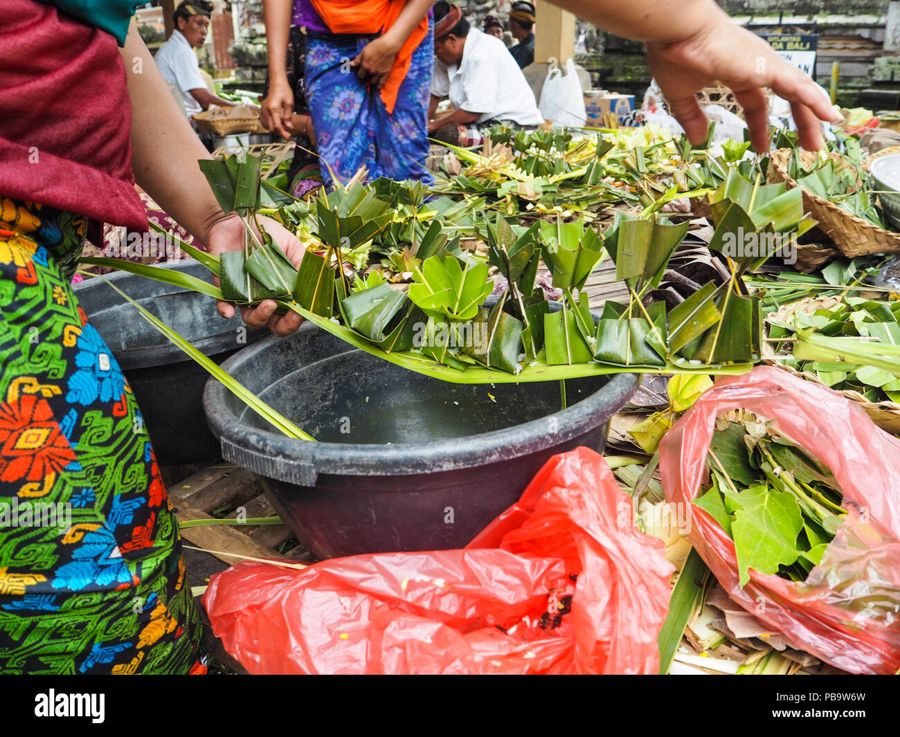 Le donne la creazione di delicati palm lasciare offerte per Nyepi Bali Foto Stock