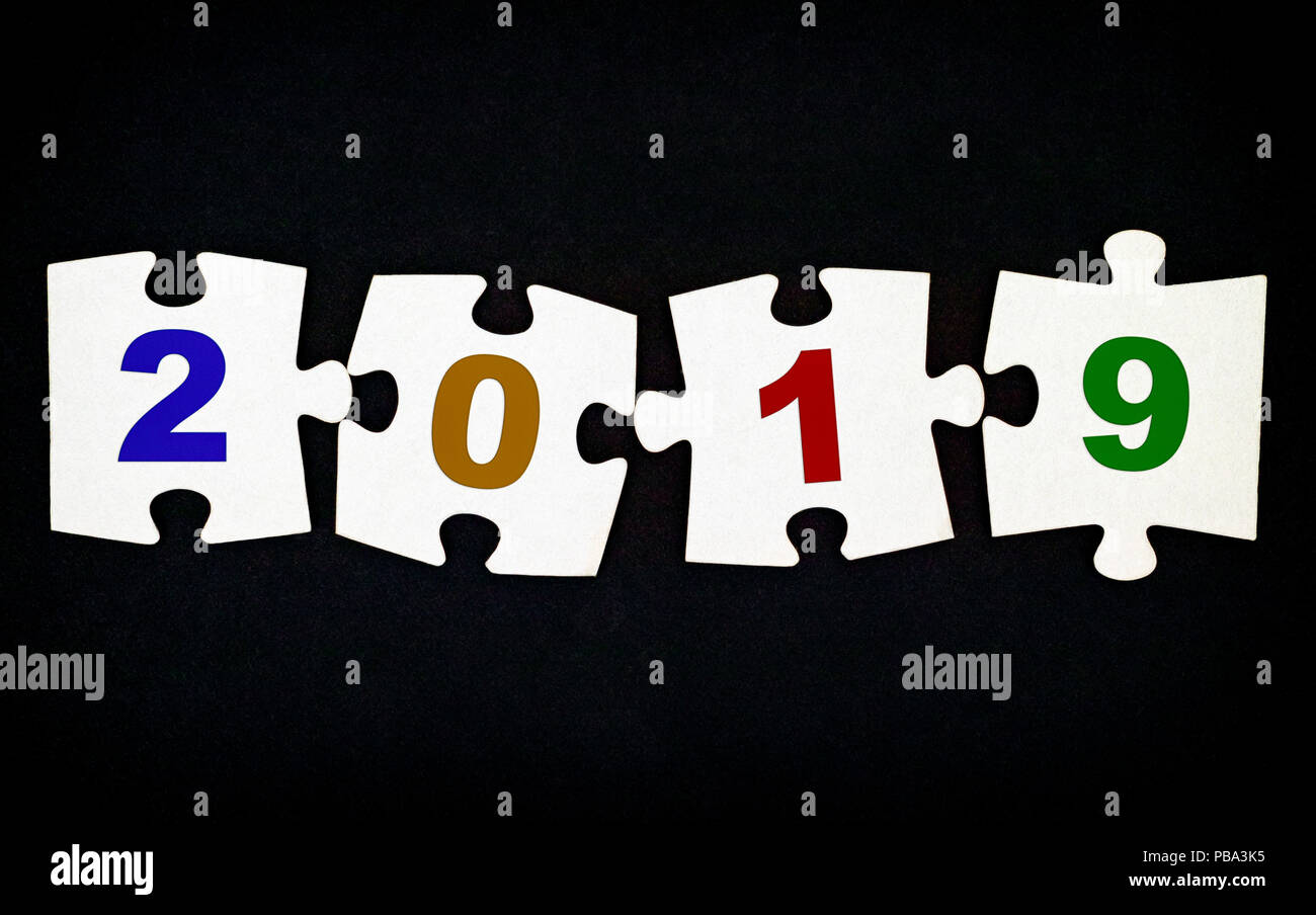Quattro pezzi di un puzzle con i numeri 2019 su sfondo nero. Close-up. Foto Stock