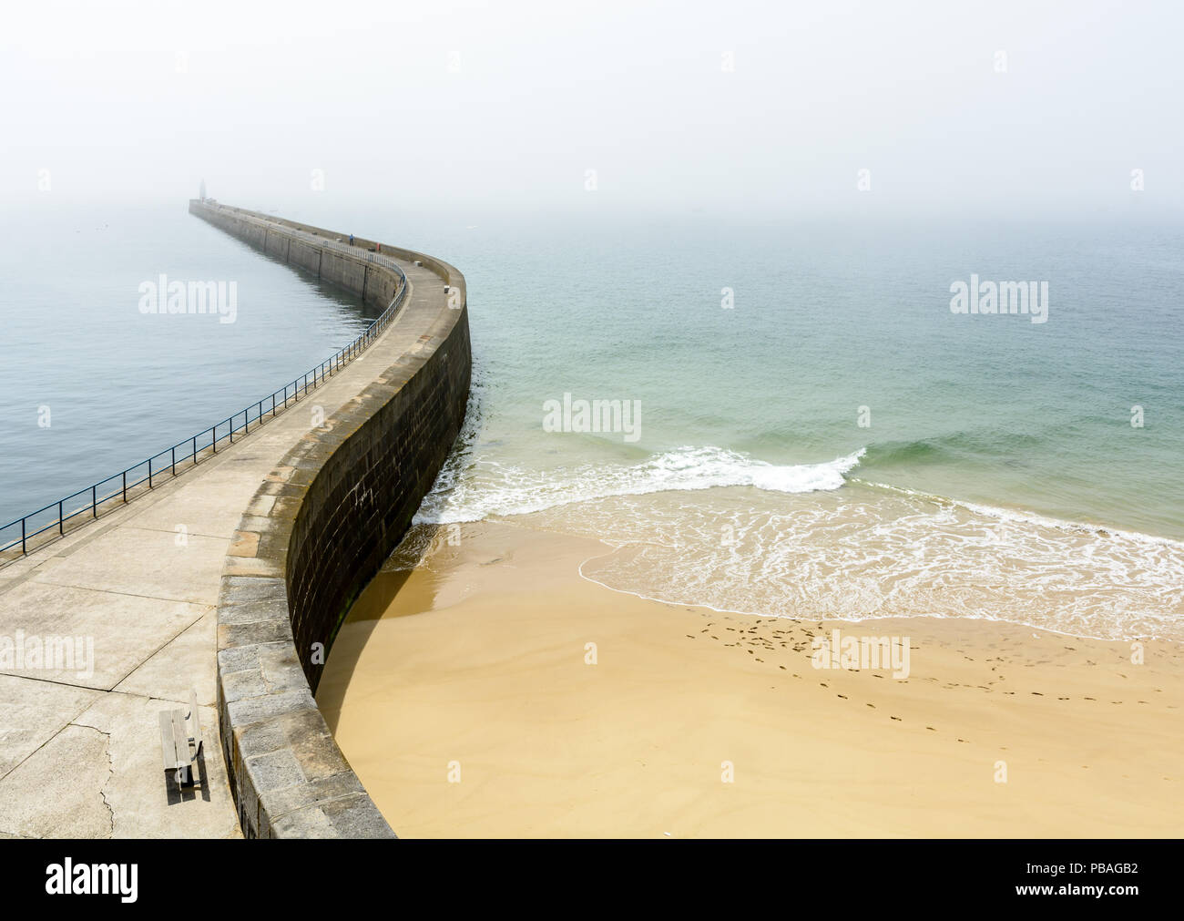 La Mole des Noires, il lungo frangiflutti delle mura di cinta della città di Saint Malo in Bretagna, Francia, e dalla Mole spiaggia da una soleggiata e nebbioso meteo. Foto Stock