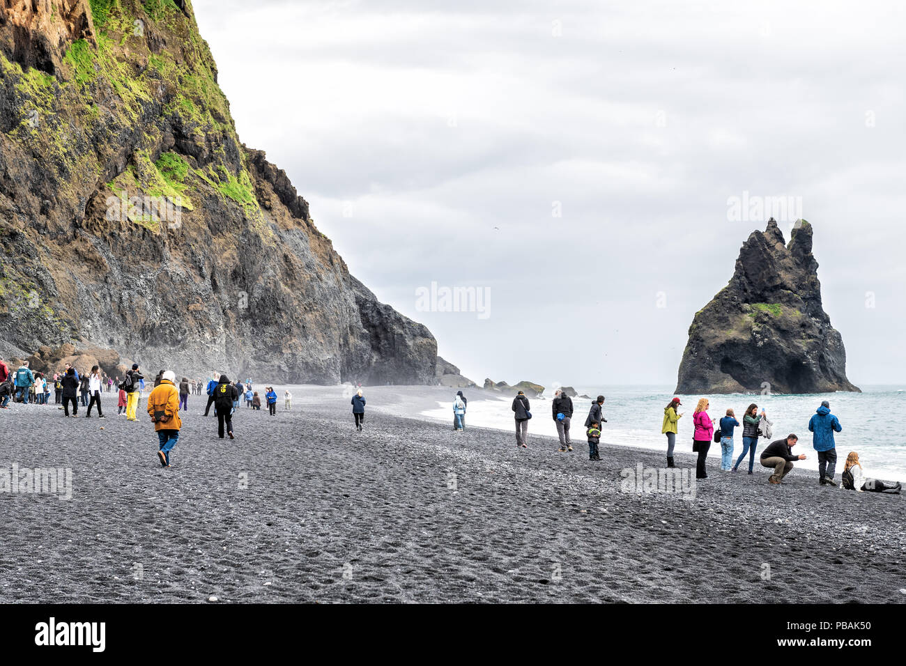 Myrdal, Islanda - 14 Giugno 2018: Reynisfjara spiaggia di sabbia nera da rocce vulcaniche, formazione, riva del mare, coste, molte persone, i turisti a piedi, taki Foto Stock