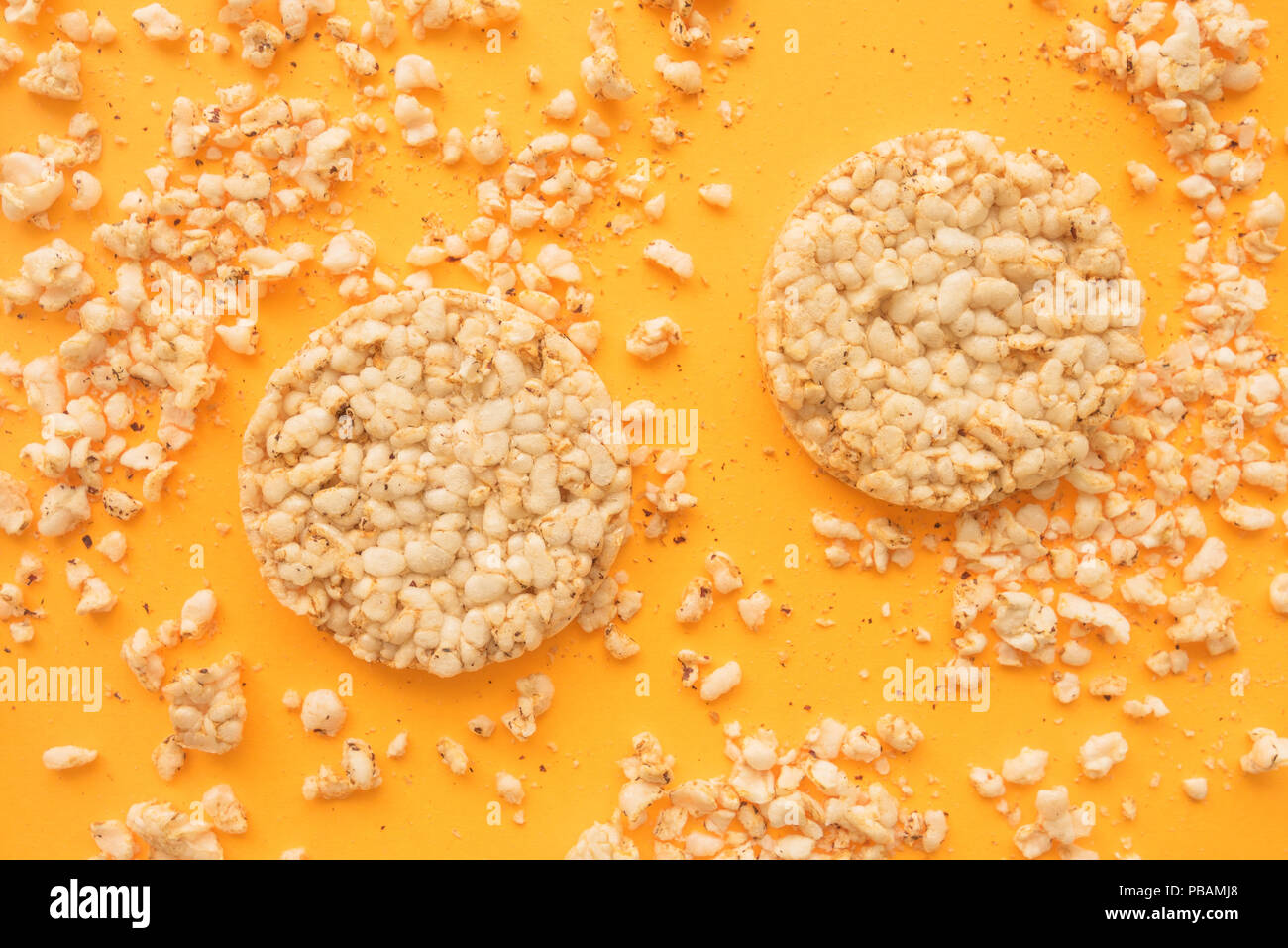 Lay piatto croccante e torte di riso su sfondo giallo, overhead vista dall'alto in basso Foto Stock