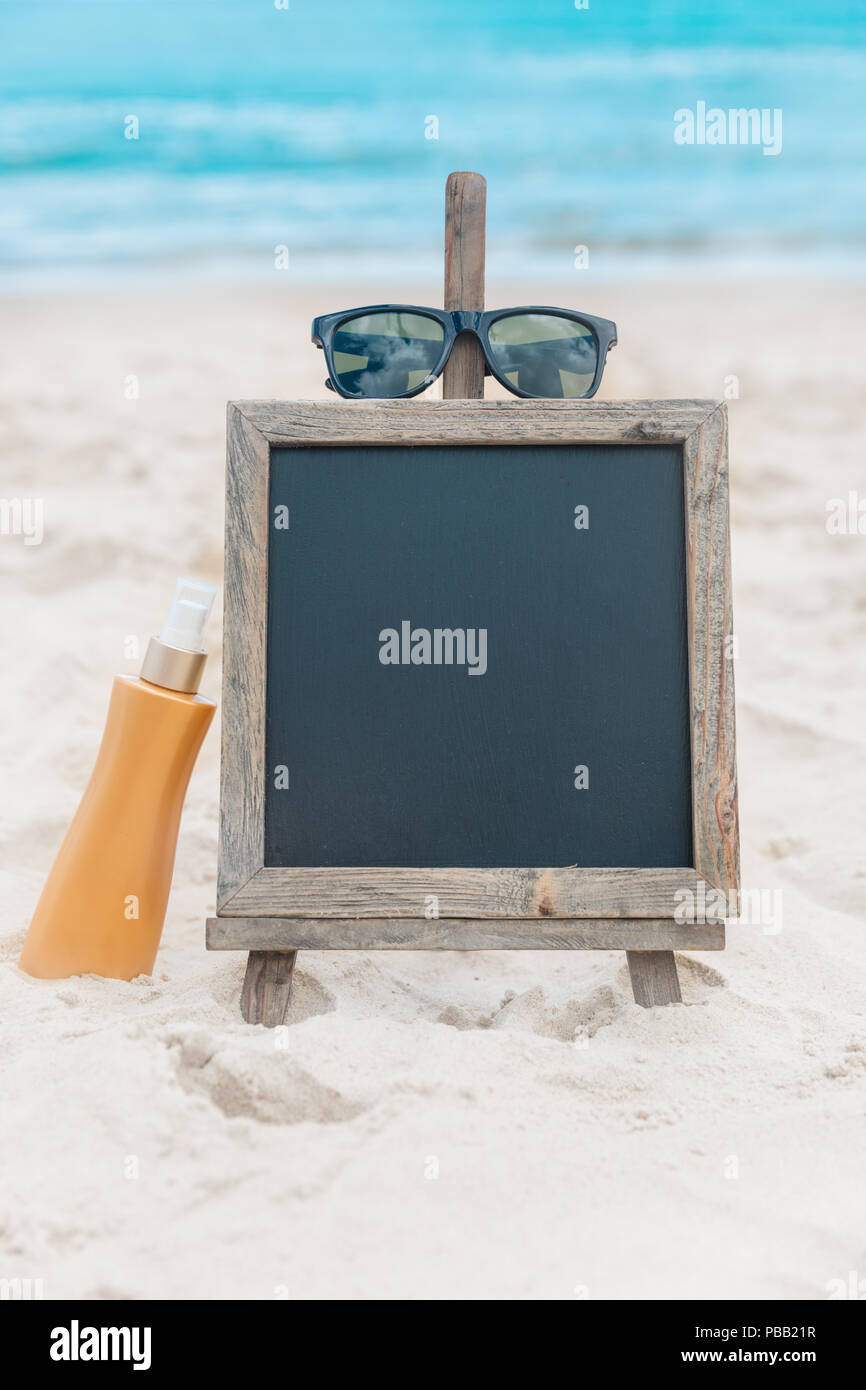 Chalk board con crema di protezione solare nella sabbia sulla spiaggia tropic sfondo esotico Foto Stock