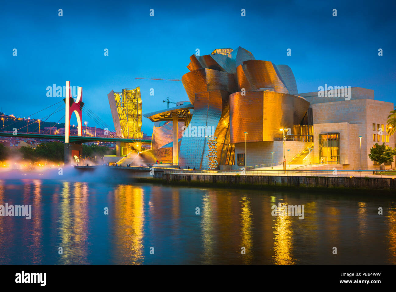 Bilbao cityscape, vista di notte attraverso il fiume verso il illuminato il Museo Guggenheim e il Puente de la Salve nel centro di Bilbao, Spagna. Foto Stock