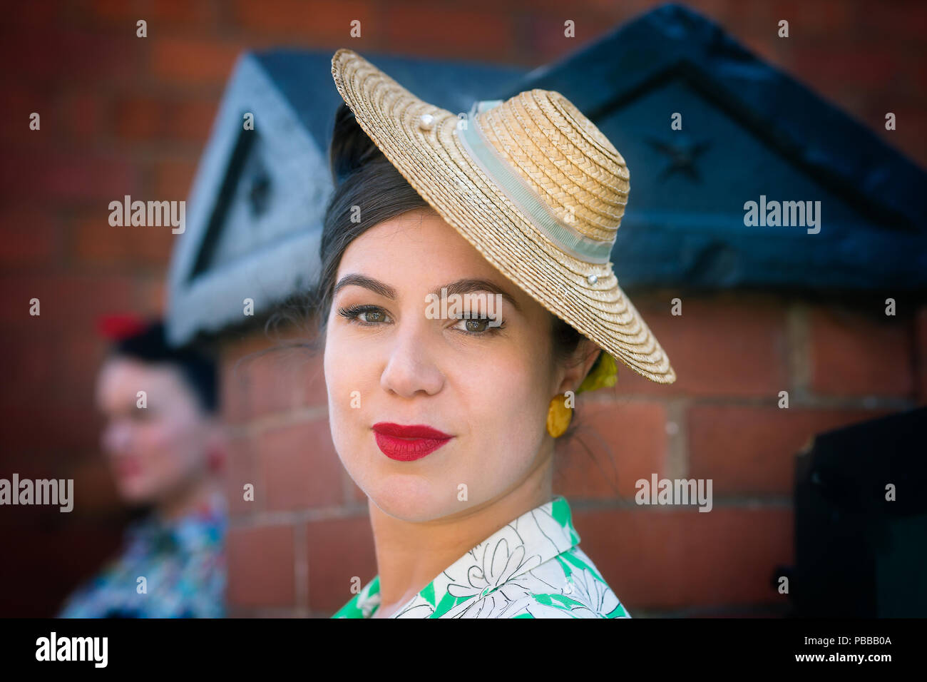 Close-up ritratto di dama elegante vista frontale, indossando il rossetto  rosso & lato inclinato attraente cappello di paglia, Black Country Museum  1940's WWII evento Foto stock - Alamy