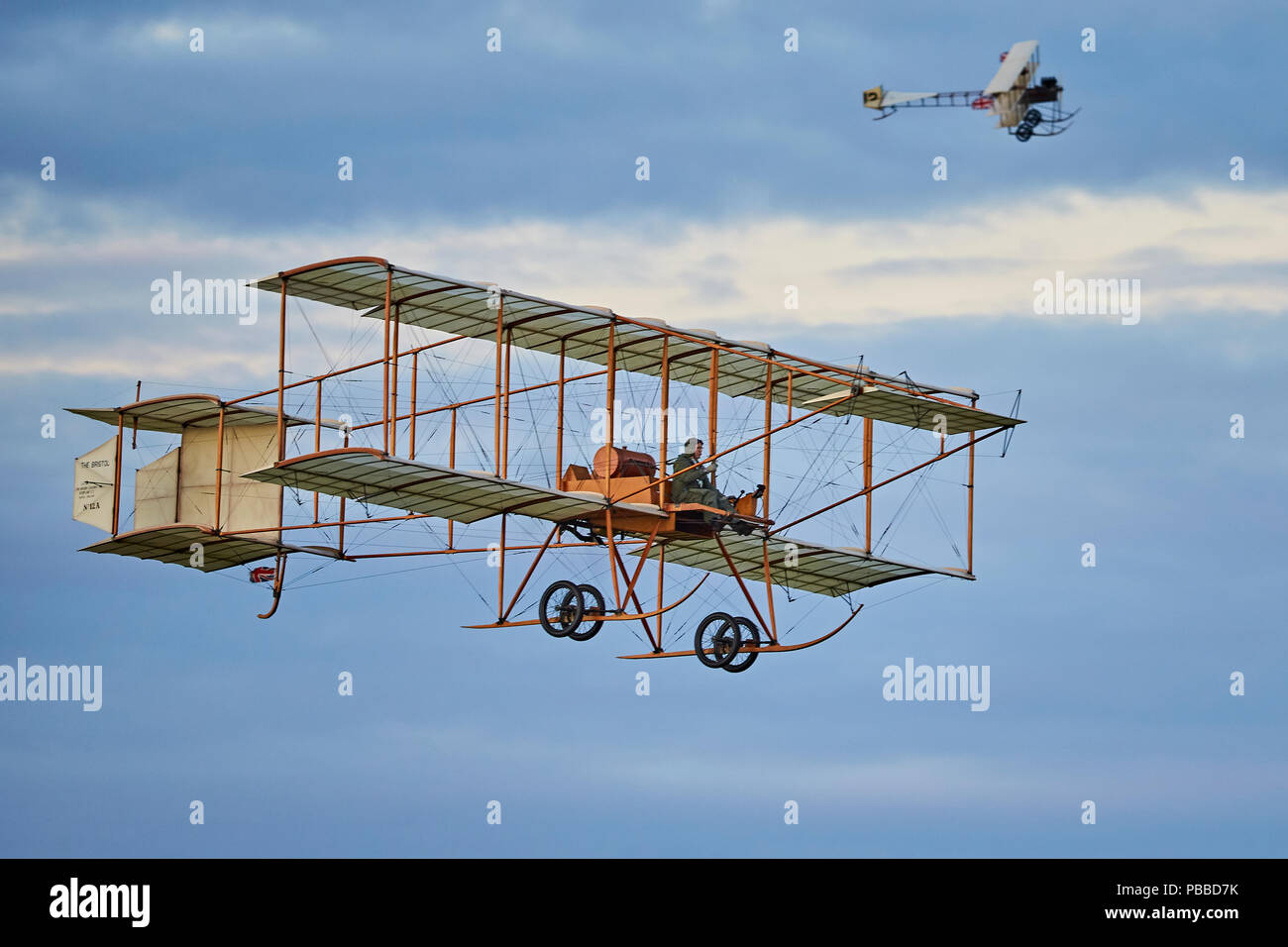 Un Bristol Boxkite replica a volare con un Avro triplano replica in background contro un tardo pomeriggio cielo molto nuvoloso Foto Stock