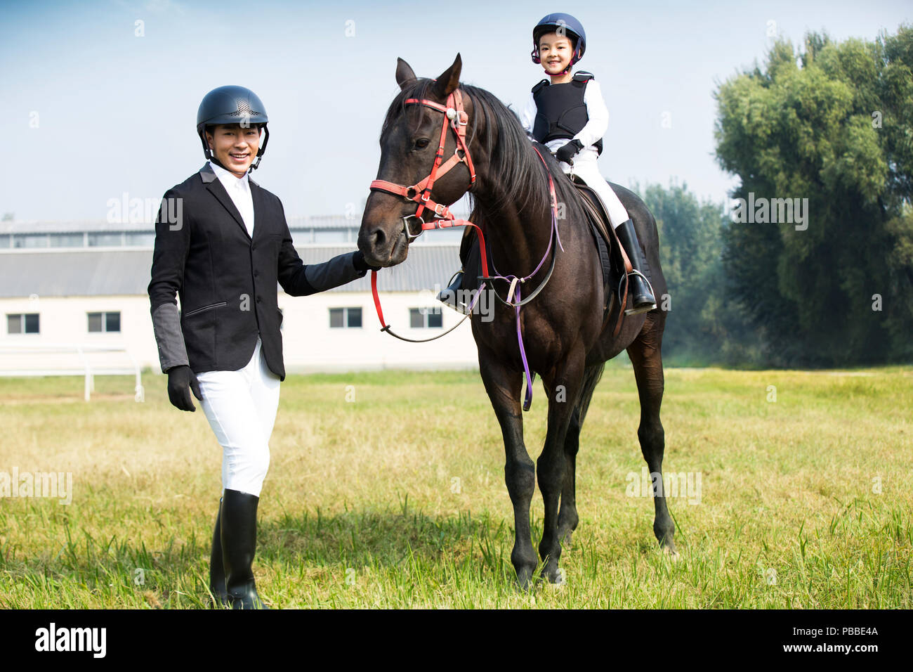 I giovani cinesi padre figlia di insegnamento di equitazione Foto Stock