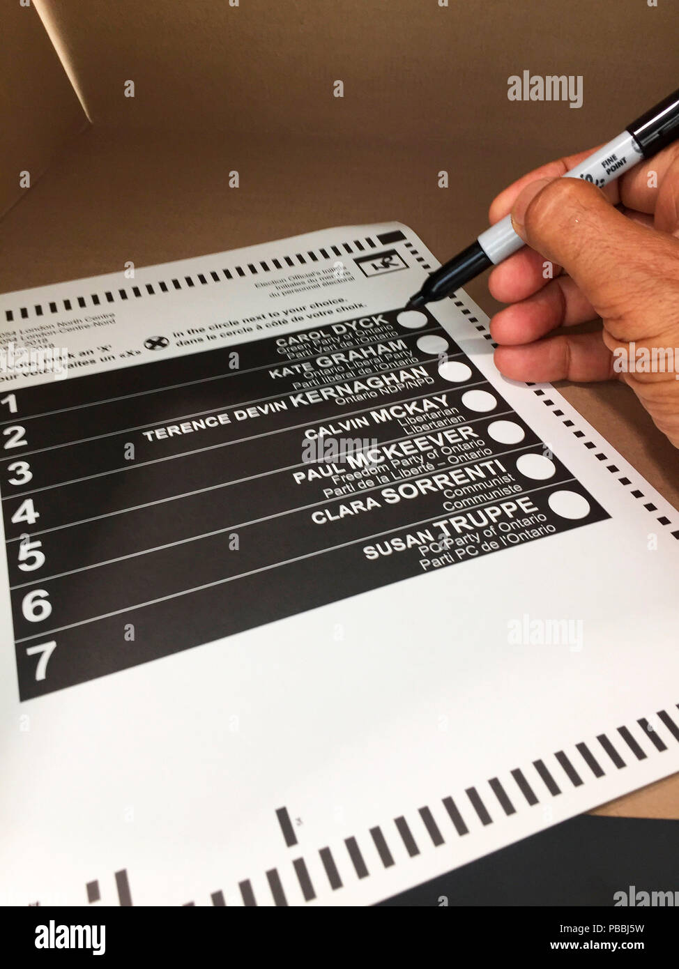 Sette candidati: un elettore circa per contrassegnare il ballottaggio con un pennarello indelebile Sharpie all'interno di uno stand per sondaggi, Ontario, Canada. Da sottoporre a scansione e contate elettronicamente. Foto Stock