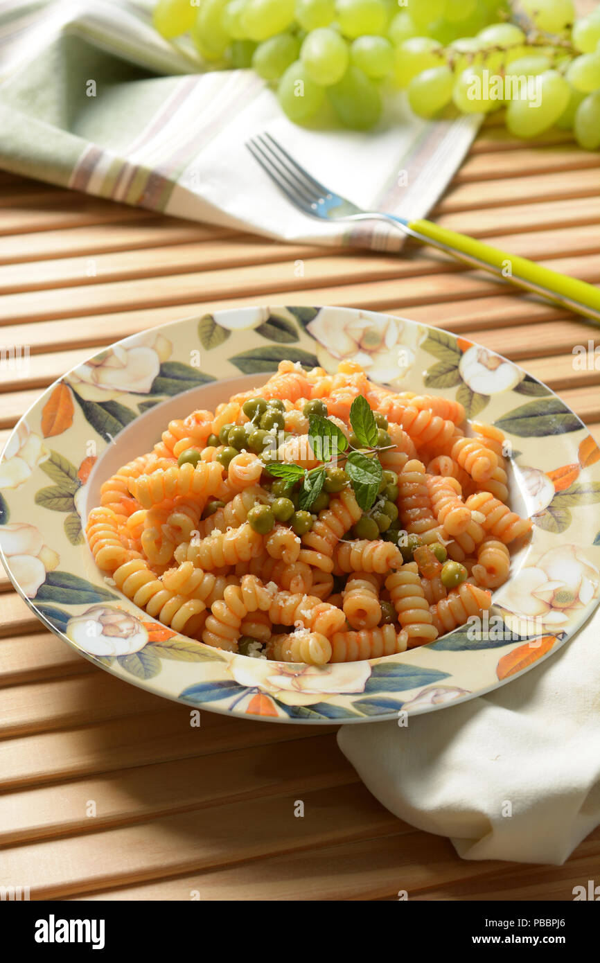 Fusilli con salsa di pomodoro e piselli - primo piano Foto Stock