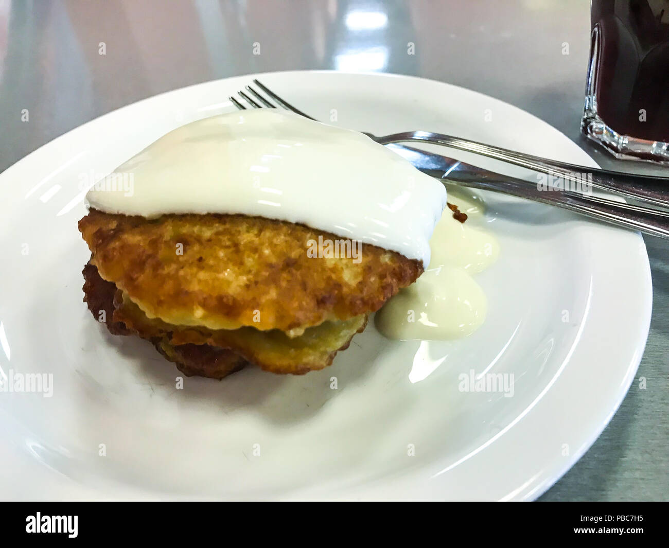 Frittelle di patate con panna acida sulla piastra bianca. Foto Studio Foto Stock