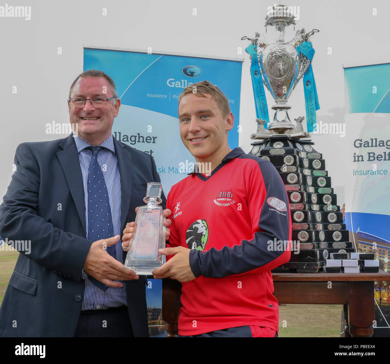 Irlanda del Nord, Regno Unito. Il 27 luglio 2018. Il verde, dalla pettinatrice, County Down. Il 27 luglio 2018. Gallagher Cup Final - Waringstown v CSNI. Waringstwon è Adam Dennison riceve un suo uomo del Match Award da Neil Hunter (Gallagher- Belfast). Credito: David Hunter/Alamy Live News. Foto Stock