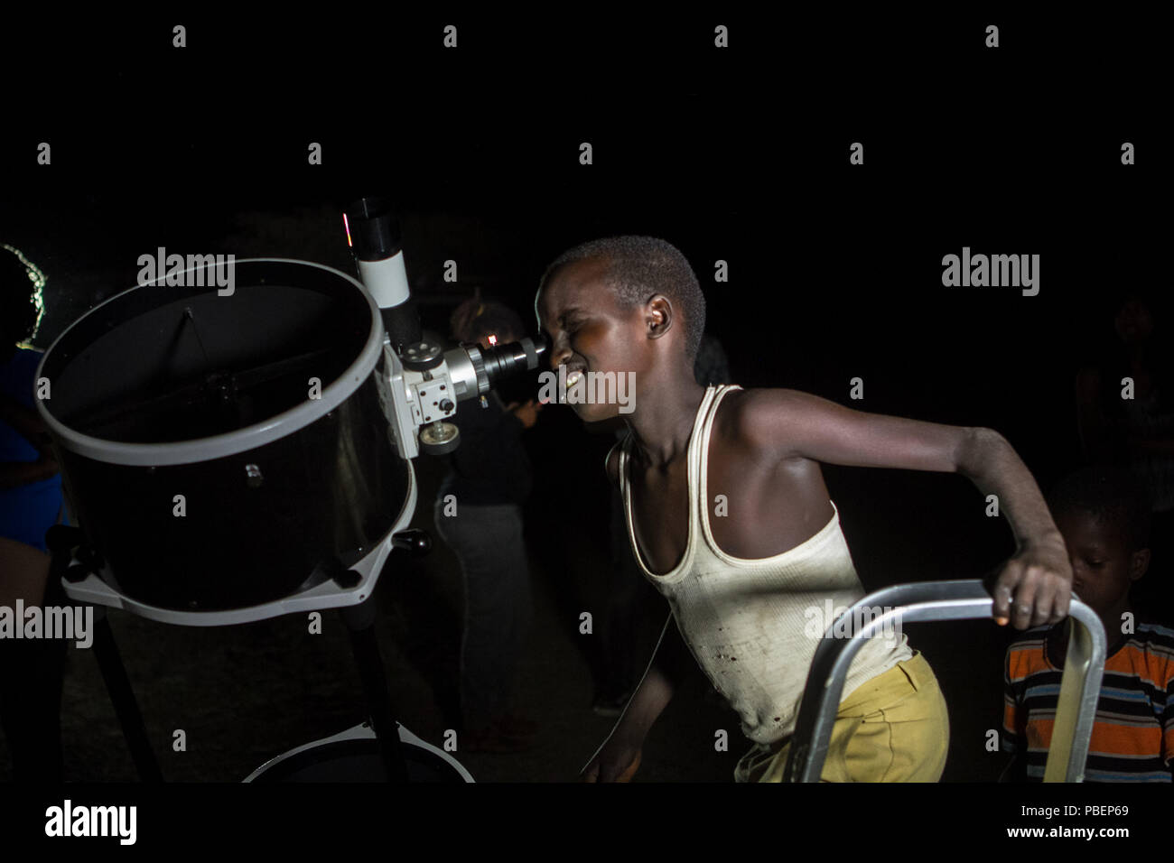 La Contea di Kajiado, Kenya. 27 Luglio, 2018. Un ragazzo keniano si vede guardando attraverso un telescopio.Persone testimonianza il Lunar Eclipse in città Oloika, Magadi in Kenya. La luna completamente coperto della terra umbra la notte del 27 luglio 2018 per 103 minuti, rendendo questo eclipse la più lunga eclissi lunare totale del XXI secolo. Credito: Bonifacio Muthoni SOPA/images/ZUMA filo/Alamy Live News Foto Stock