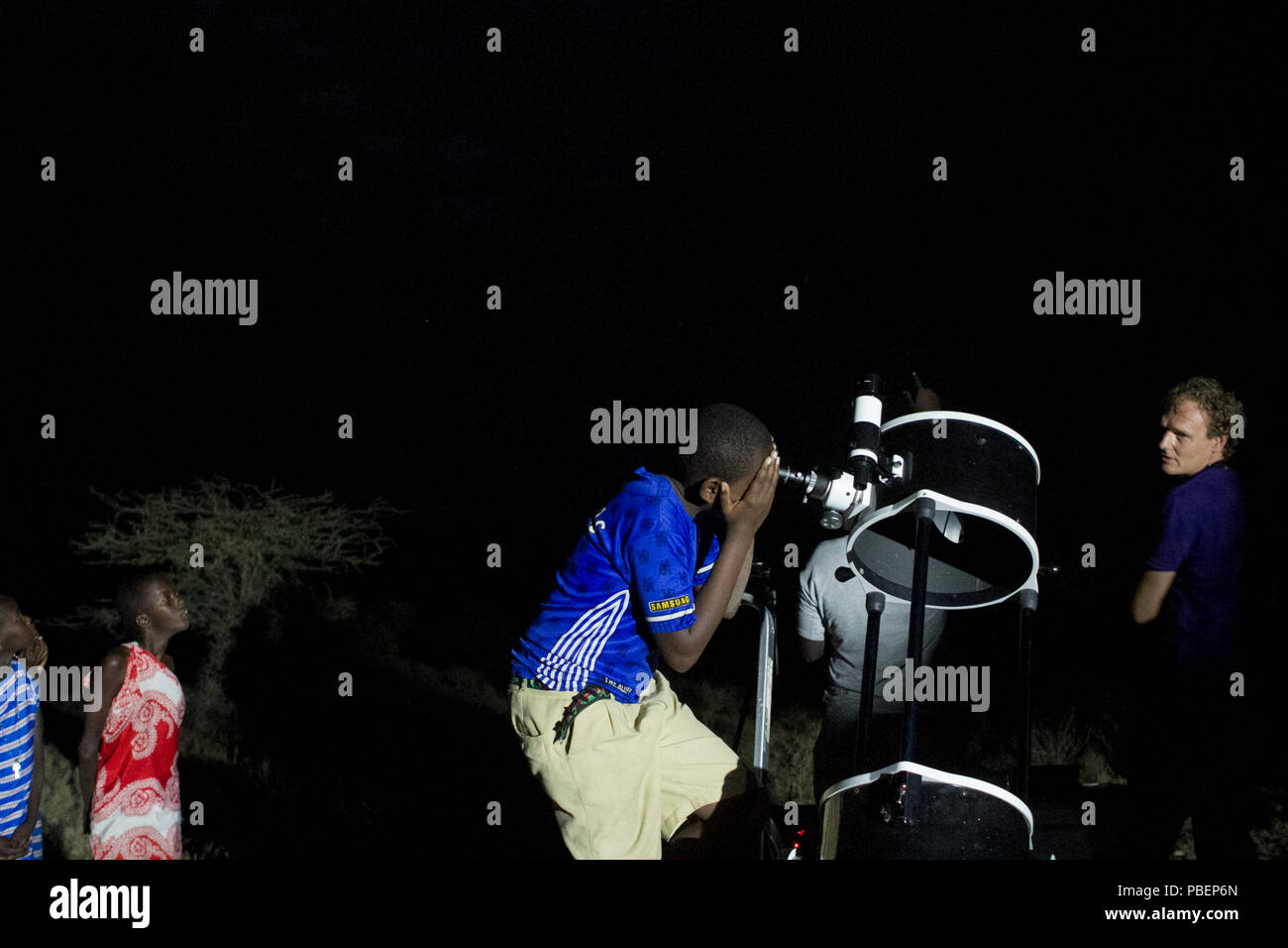 La Contea di Kajiado, Kenya. 27 Luglio, 2018. Un ragazzo keniano si vede guardando attraverso un telescopio.Persone testimonianza il Lunar Eclipse in città Oloika, Magadi in Kenya. La luna completamente coperto della terra umbra la notte del 27 luglio 2018 per 103 minuti, rendendo questo eclipse la più lunga eclissi lunare totale del XXI secolo. Credito: Bonifacio Muthoni SOPA/images/ZUMA filo/Alamy Live News Foto Stock