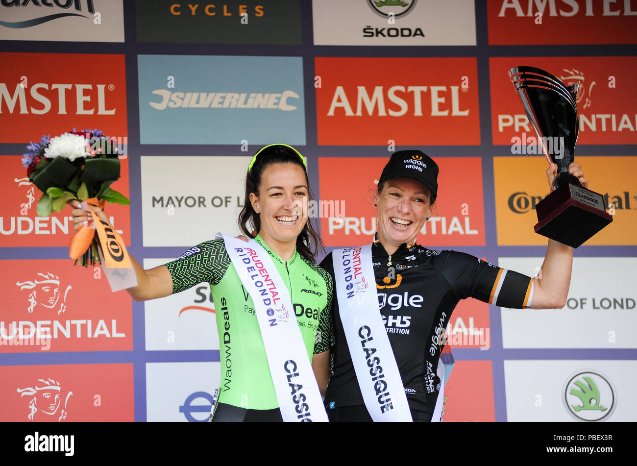 Il centro di Londra, Inghilterra, Regno Unito. Il 28 luglio 2018. Kristen Selvaggio, Wiggins alta5 con i vincitori del trofeo dopo la vittoria del Prudential RideLondon Classique, con Dani Rowe, Waowdeals Procycling, vincitore della classifica sprint. parte di Prudential RideLondon Festival di fine settimana in bicicletta. @ David Partridge / Alamy Live News Foto Stock