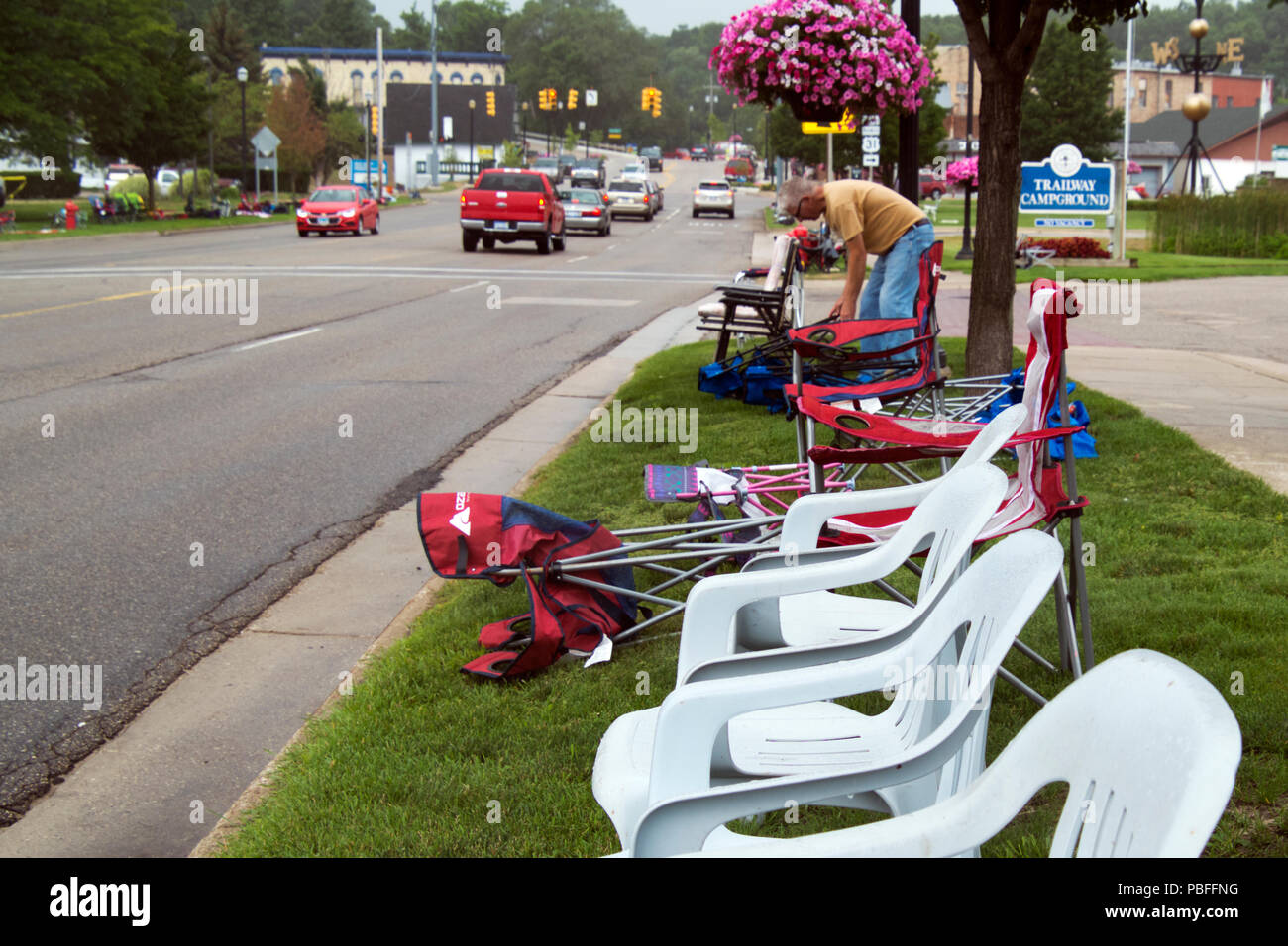 Posizioni di uomo la sua sedia accanto alla strada in previsione del 2018 annuale parata Cruz-In per antichi e veicoli vintage attraverso Montague, Michigan Foto Stock