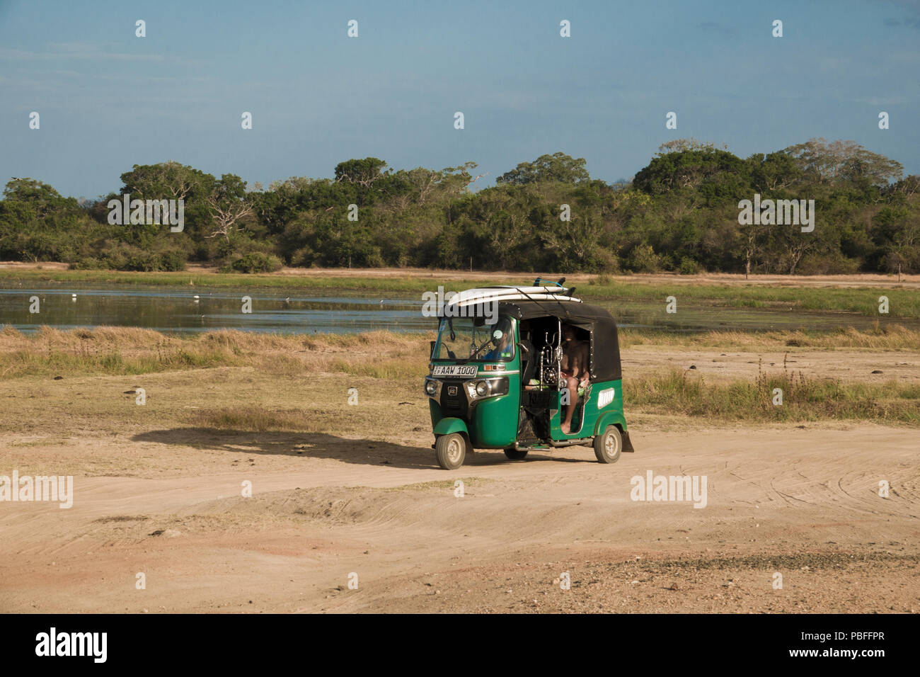 Un tuk tuk taxi caricato con tavole da surf trasporta i surfisti alle onde attraverso la giungla di fattoria di arachidi beach, Sri Lanka Foto Stock