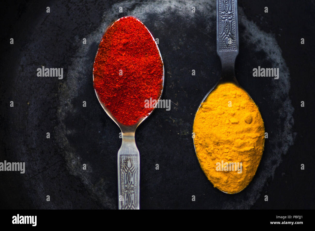 Due cucchiai di spezie indiane. Questi sono i principali ingredienti della cucina indiana in tutto il subcontinente. Questi sono chiamati curcuma e rosso piccante. Foto Stock