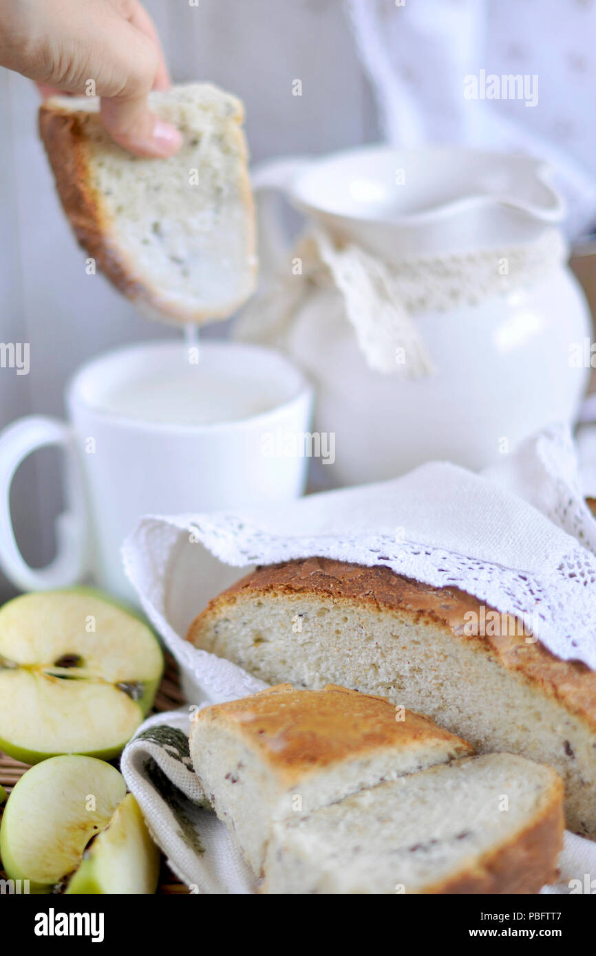 Homebaked pane. prodotti da forno. il latte in una brocca. vintage tovaglioli e tovaglia. tagliare apple Foto Stock