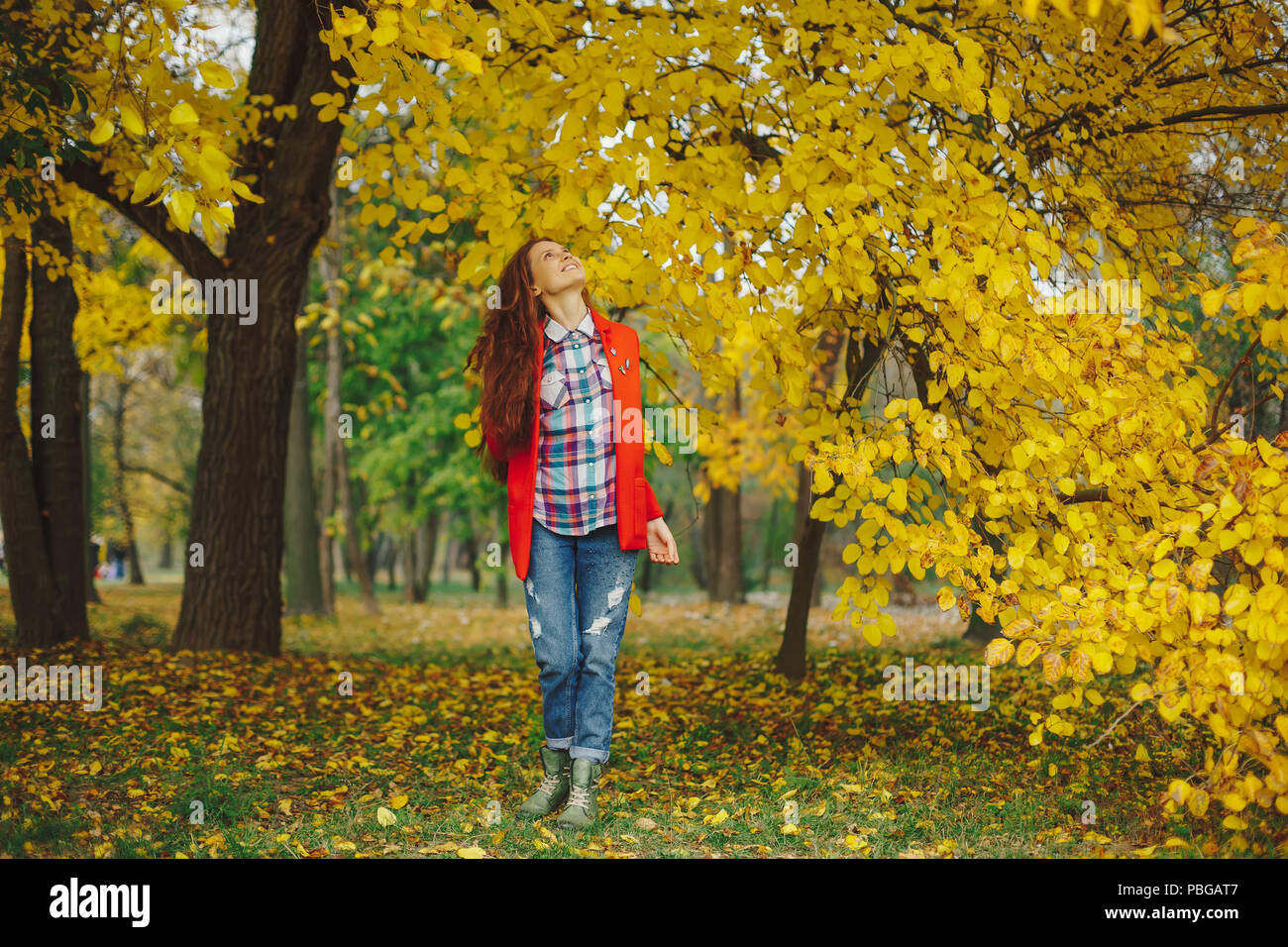 Felice ragazza cercando entusiasti di alberi di autunno Foto Stock