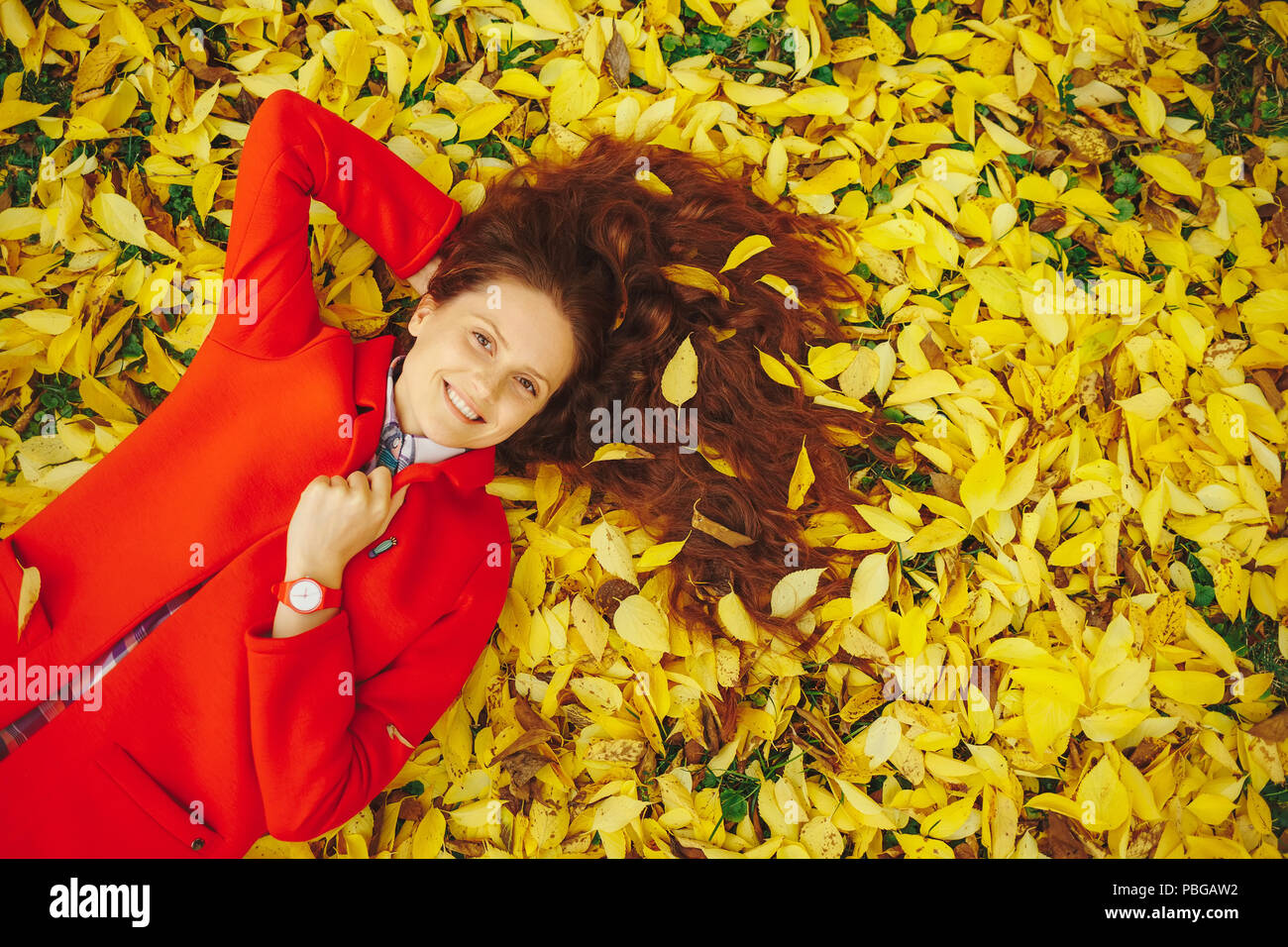 Giovane bella signora circondato Foglie di autunno Foto Stock