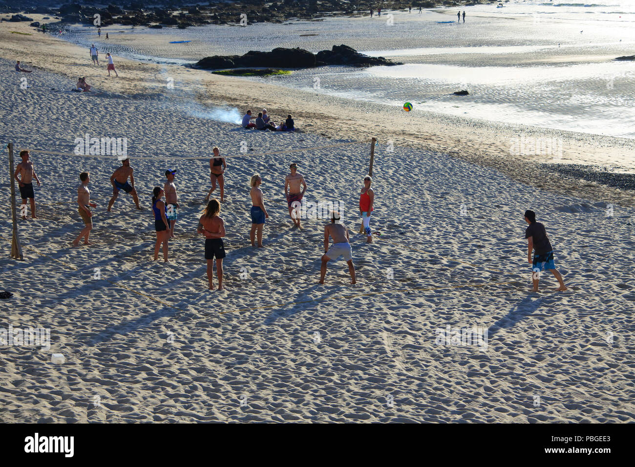 I turisti giocava a pallavolo in spiaggia Porthmeor, St. Ives, Cornwall, Regno Unito - Giovanni Gollop Foto Stock