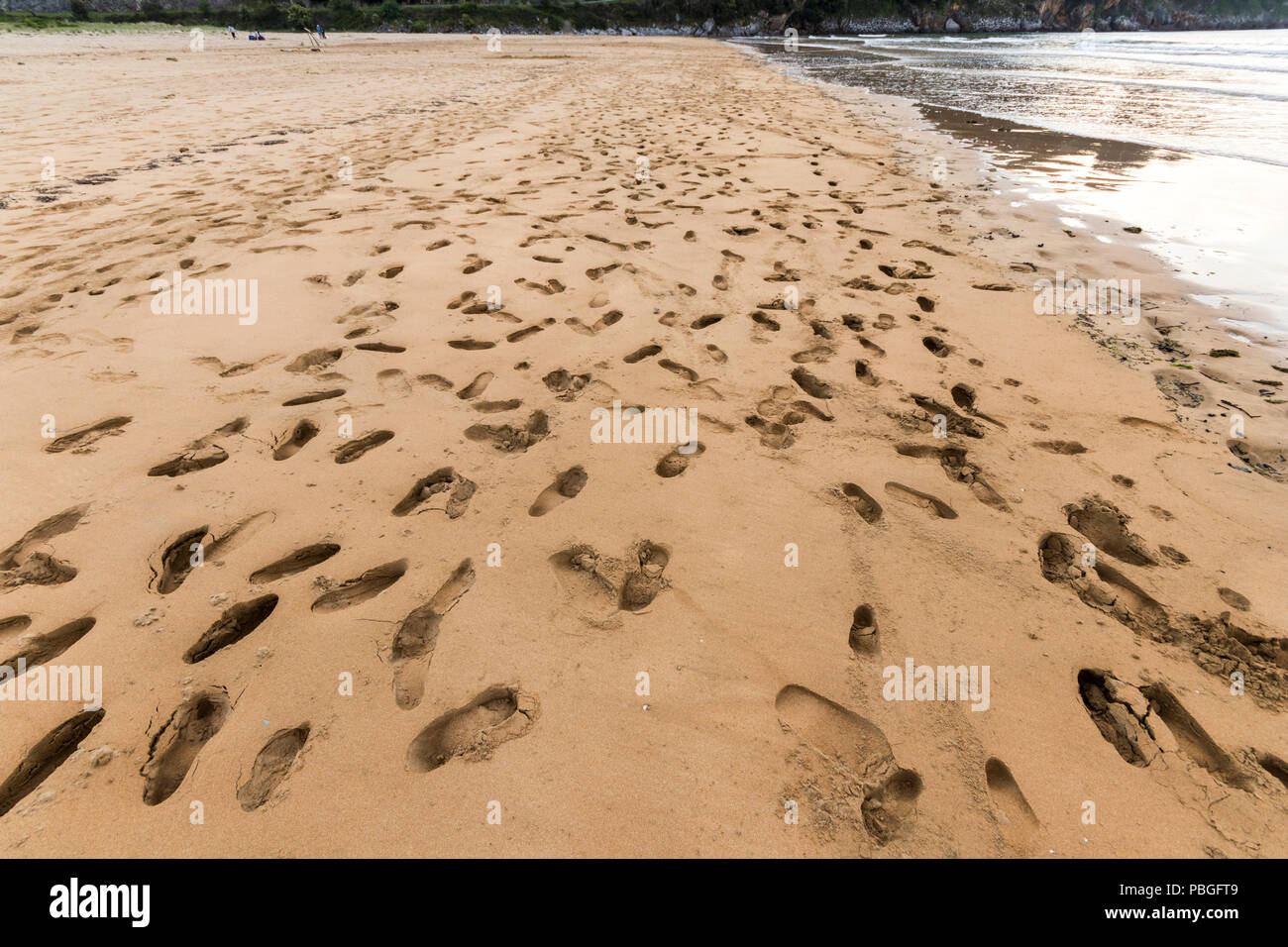 Orinon, Spagna. Orme nella sabbia di Playa de Orinon, una spiaggia nel piccolo villaggio di Orinon nel comune di Castro Urdiales, Cantabria Foto Stock