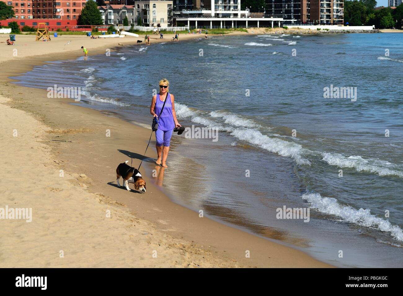 Chicago, Illinois, Stati Uniti d'America. Una donna che cammina lungo la sabbia in una mattinata estiva di Hollywood Beach, noto anche come Kathy Osterman Beach. Foto Stock
