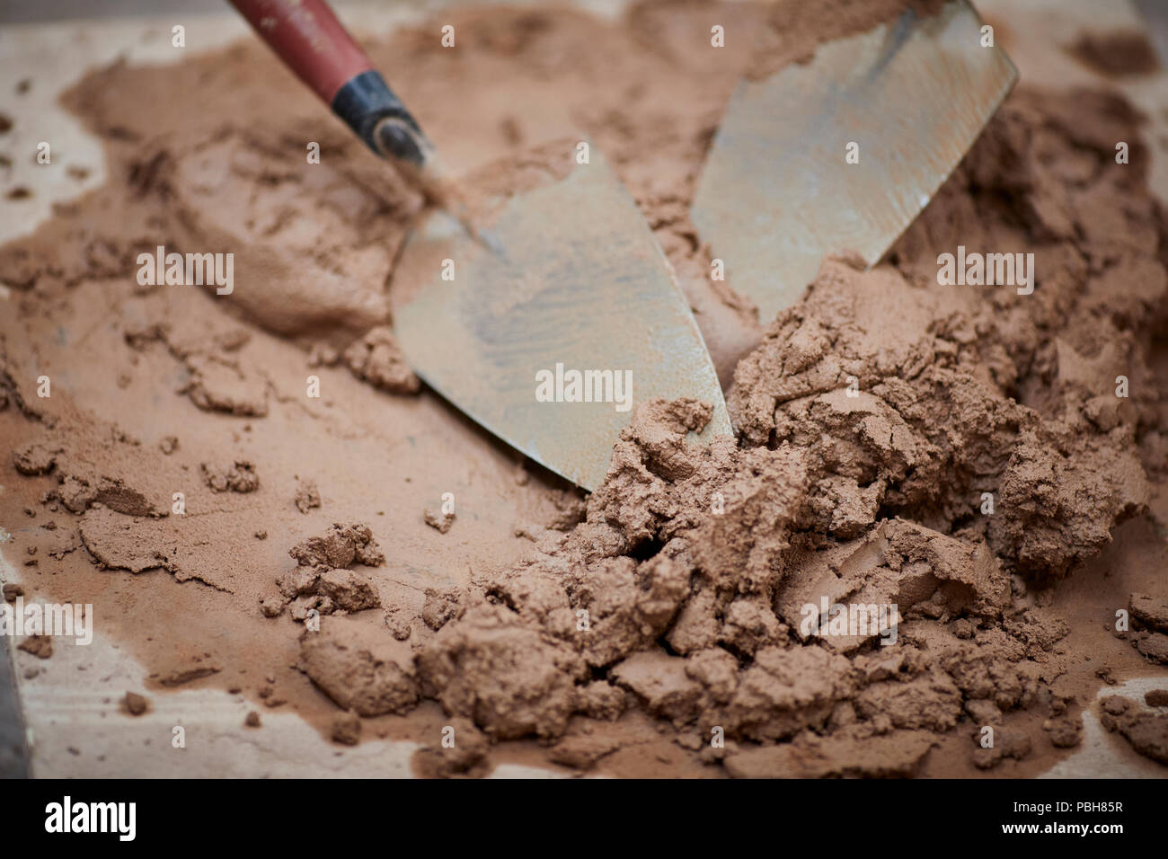 Gli strumenti del mestiere per i costruttori, muratori, homebuilders. una  cazzuola in un impasto di cemento e sabbia mix di malta Foto stock - Alamy