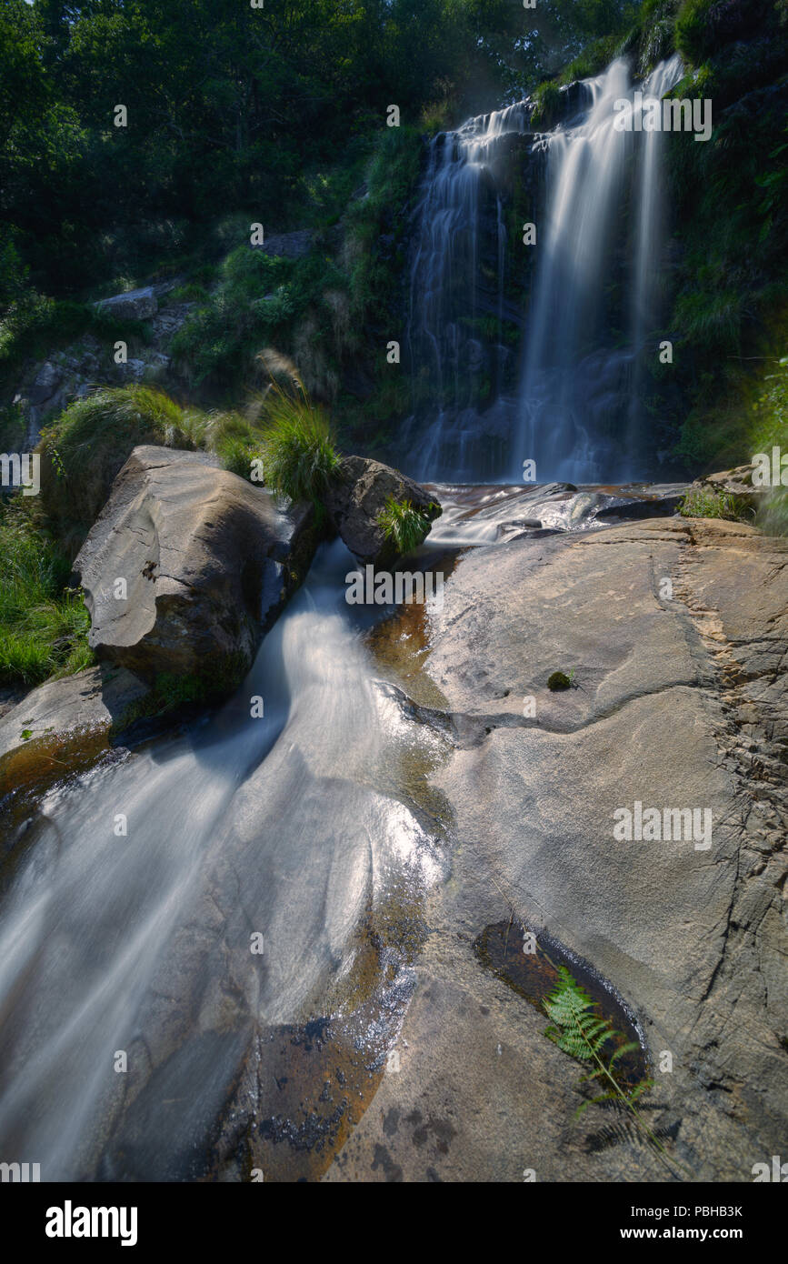 Rocas graníticas pulidas por el agua de onu arroyo y cascada Foto Stock