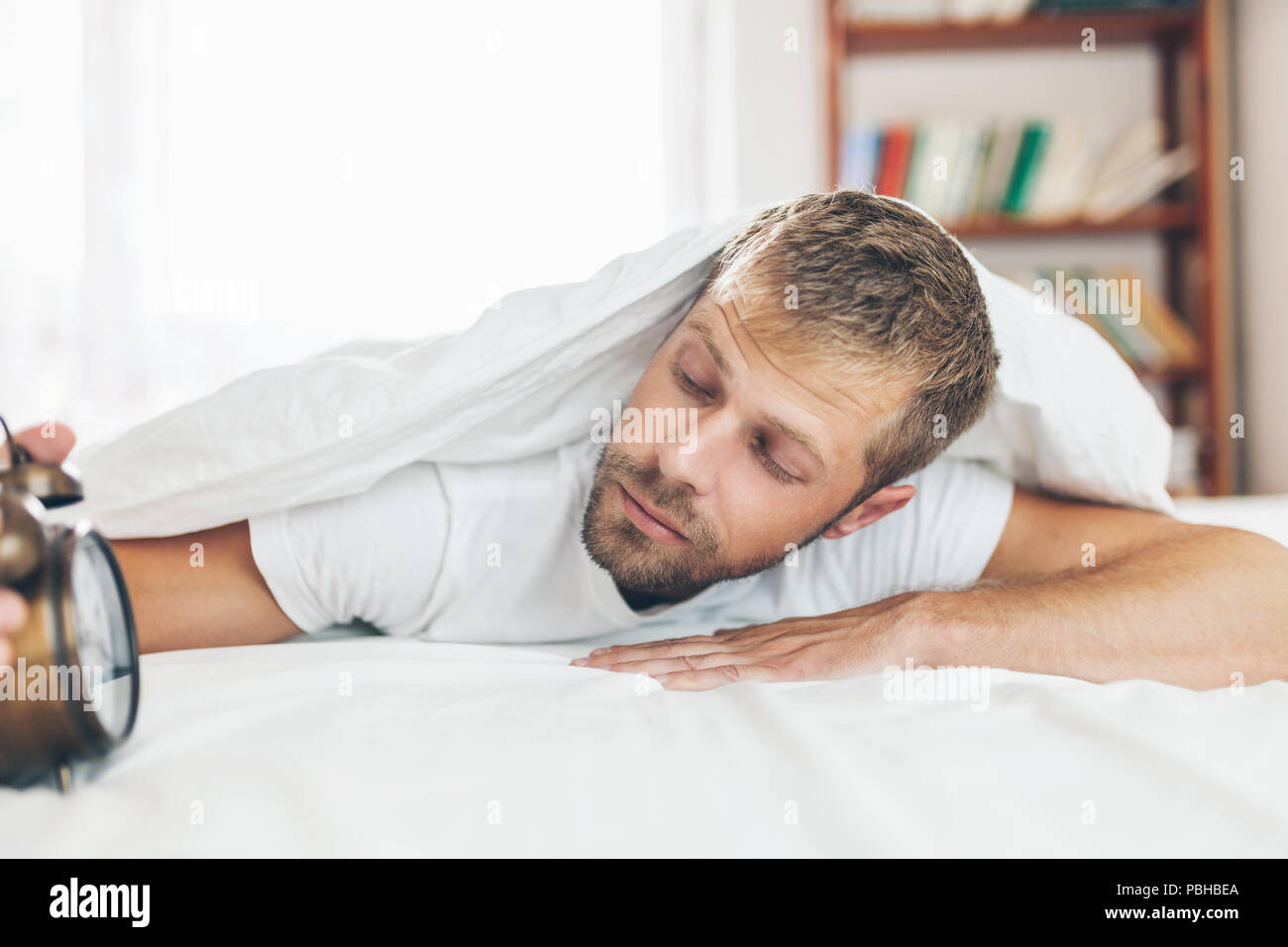 Giovane uomo a trovare difficoltà a svegliarsi al mattino Foto stock - Alamy