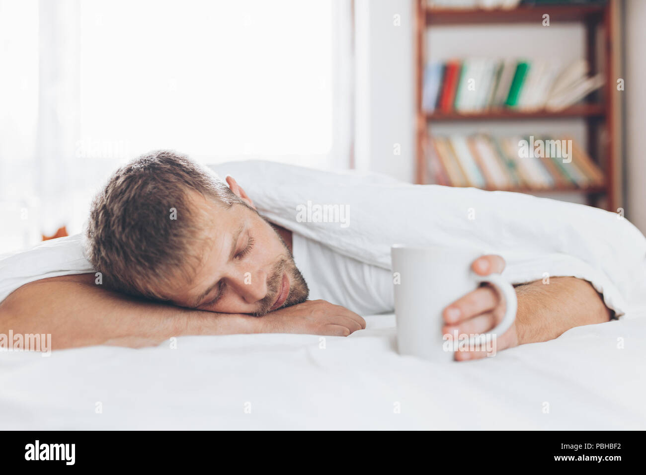 L'uomo cerca di svegliarsi la mattina dopo la notte fuori Foto Stock