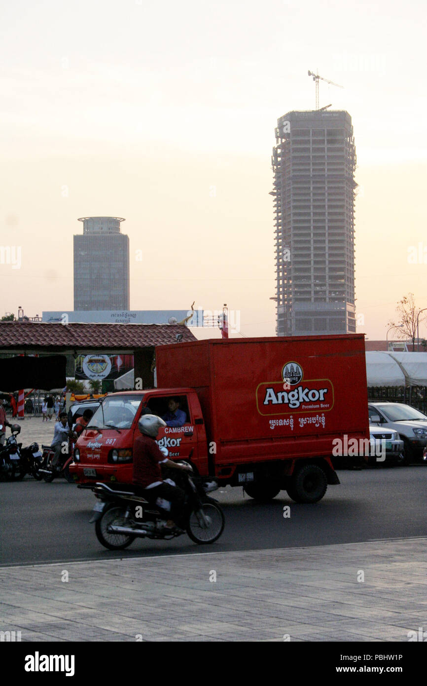 Red Van con birra Angkor grafica sul lato nella strada accanto a moto, Phnom Penh Cambogia Foto Stock