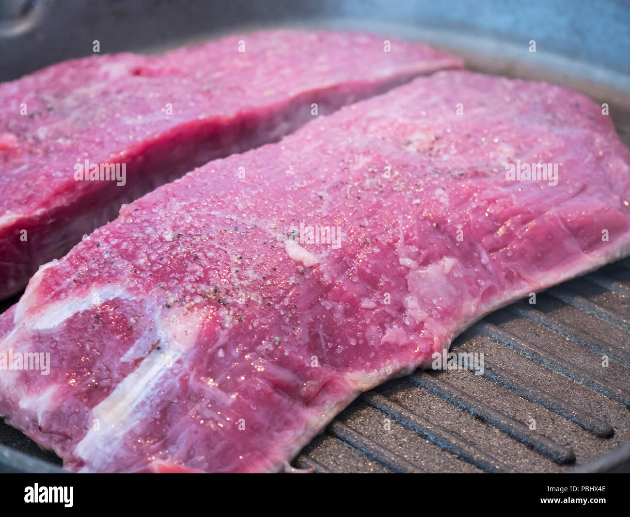 Condito materie bovine bistecca di fianco sul caldo brasiera Foto Stock