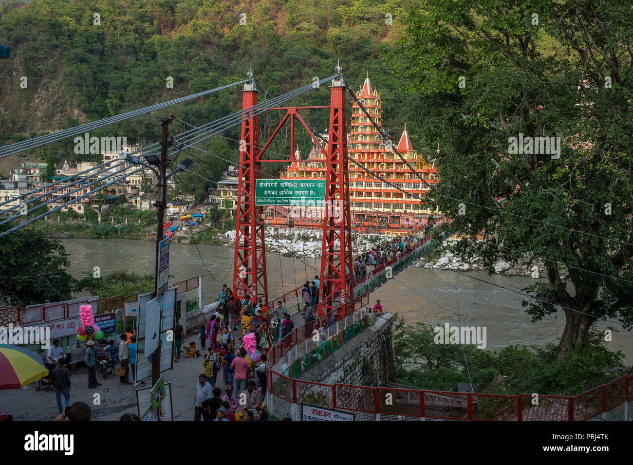 Lakshman Jhula ponte in ferro ponte di sospensione al di là del fiume Gange, Rishikesh, India Foto Stock