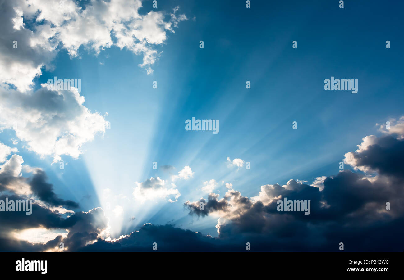 Raggi di sole da dietro le nuvole Foto Stock