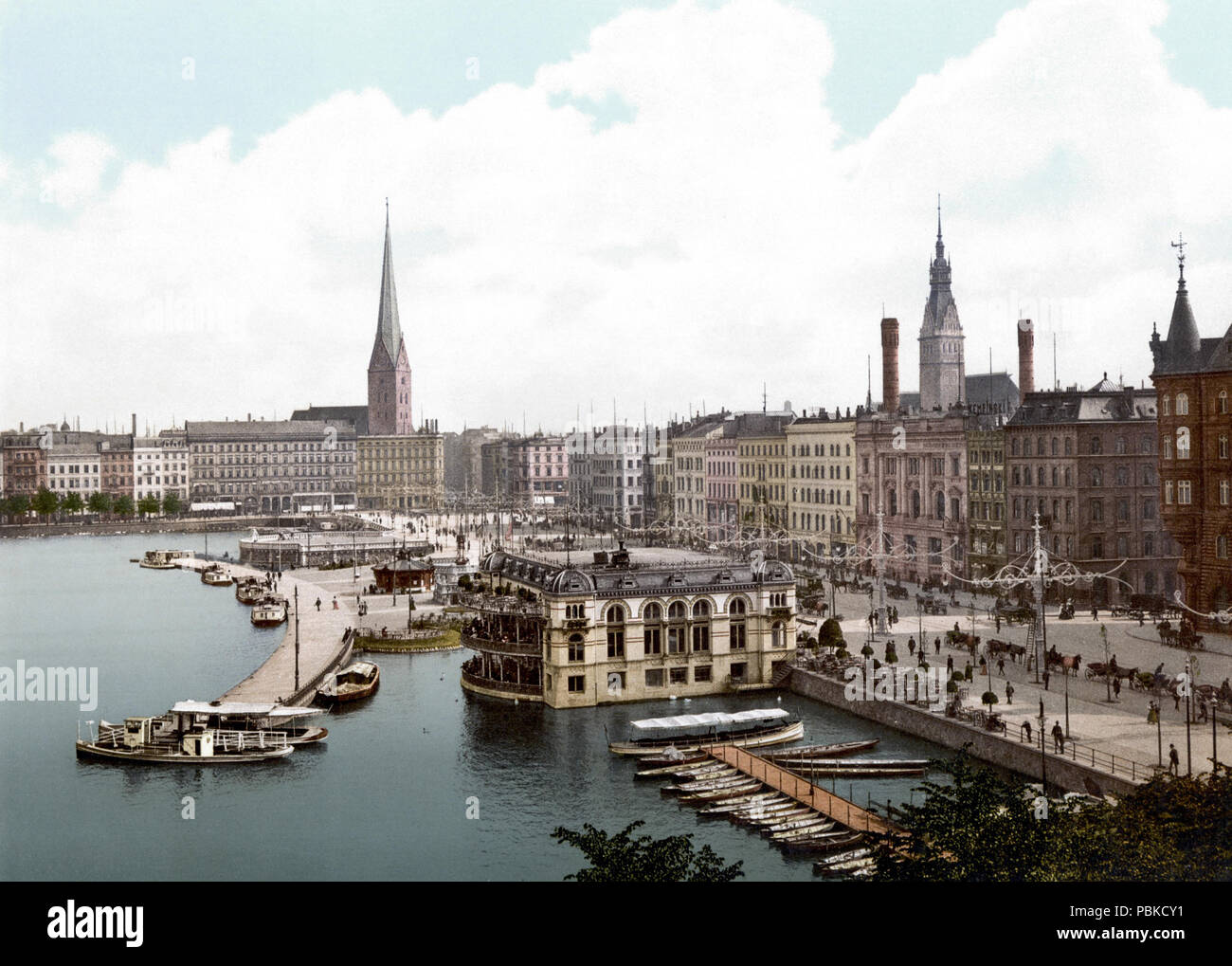 . Deutsch: Jungfernstieg in Amburgo. Inglese: Vecchio vista di Amburgo, tra 1900 e 1914. Inizio in basso a destra di Amburgo broadway Jungfernstieg conduce direttamente a uno di Amburgo chiese principali, St. Petri, sulla sinistra. La torre di destra quella del municipio, anche se gli orologi sono mancanti. Nella parte inferiore sinistra dell'immagine si può vedere il Binnenalster, il più piccolo dei due laghi formati dal fiume Alster, nel cuore di Amburgo. Nel centro della famosa Alster Pavillon, una caffetteria stabilito nel 1799 e ancora aperta. Questo è il quarto edificio, che esisteva tra il 1900 un Foto Stock