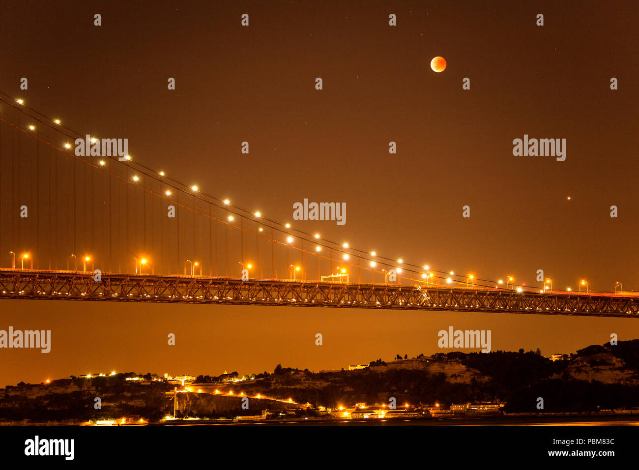 Vista dell'eclisse lunare, la più lunga luna di sangue del XXI secolo, oltre il Ponte 25 Aprile a Lisbona, Portogallo Foto Stock