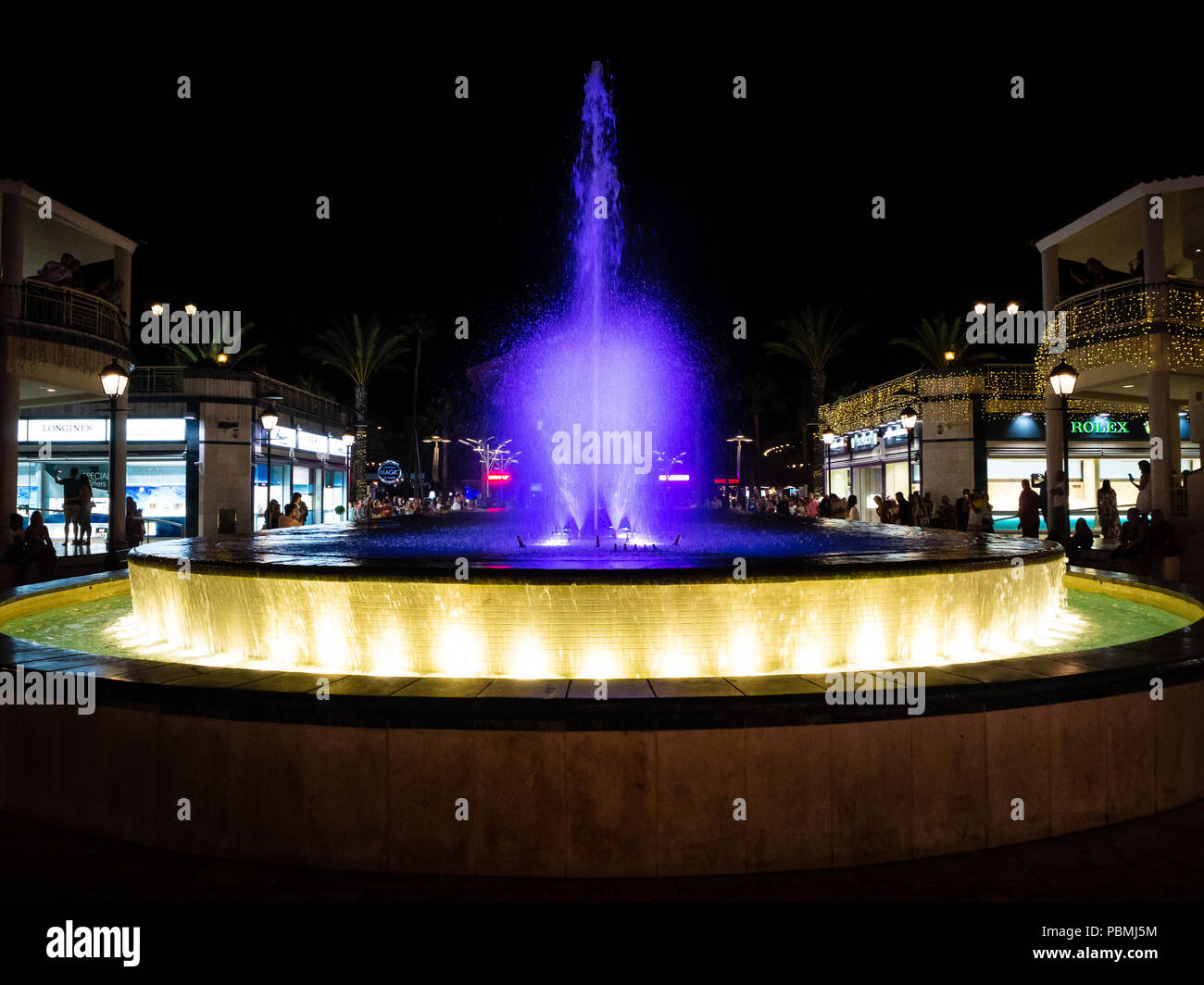 Playa de Las Americas, Tenerife, Spagna - 10 Luglio 2018: Vista di fontane illuminate di prestazioni in Las Americas circondato da negozi di lusso in Tenerif Foto Stock
