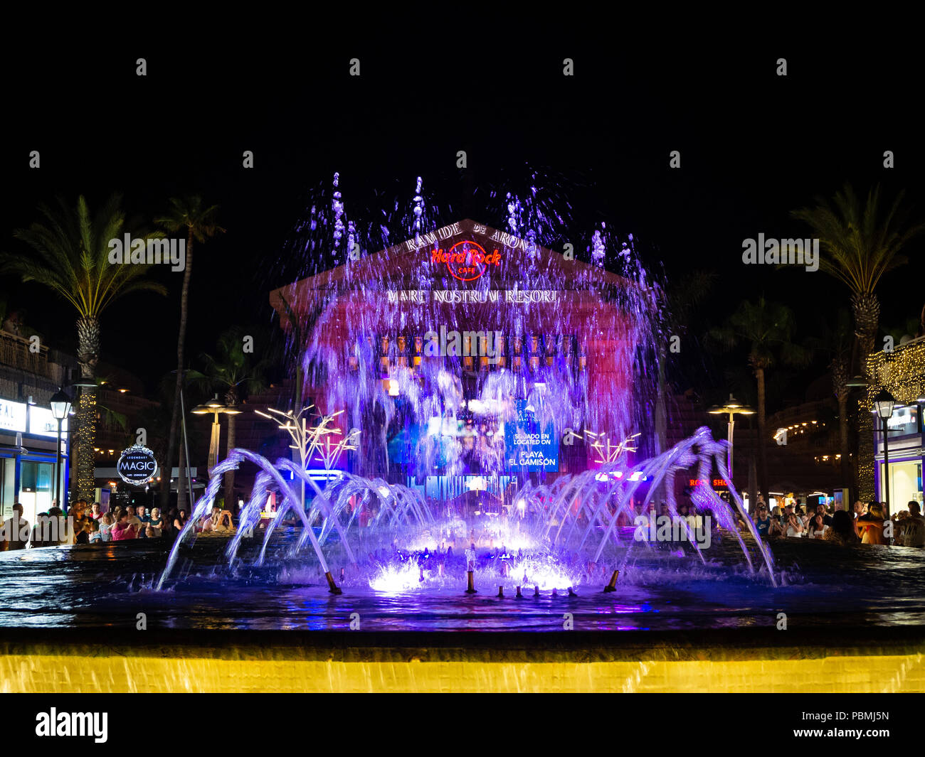 Playa de Las Americas, Tenerife, Spagna - 10 Luglio 2018: Vista di fontane illuminate di prestazioni in Las Americas circondato da negozi di lusso in Tenerif Foto Stock