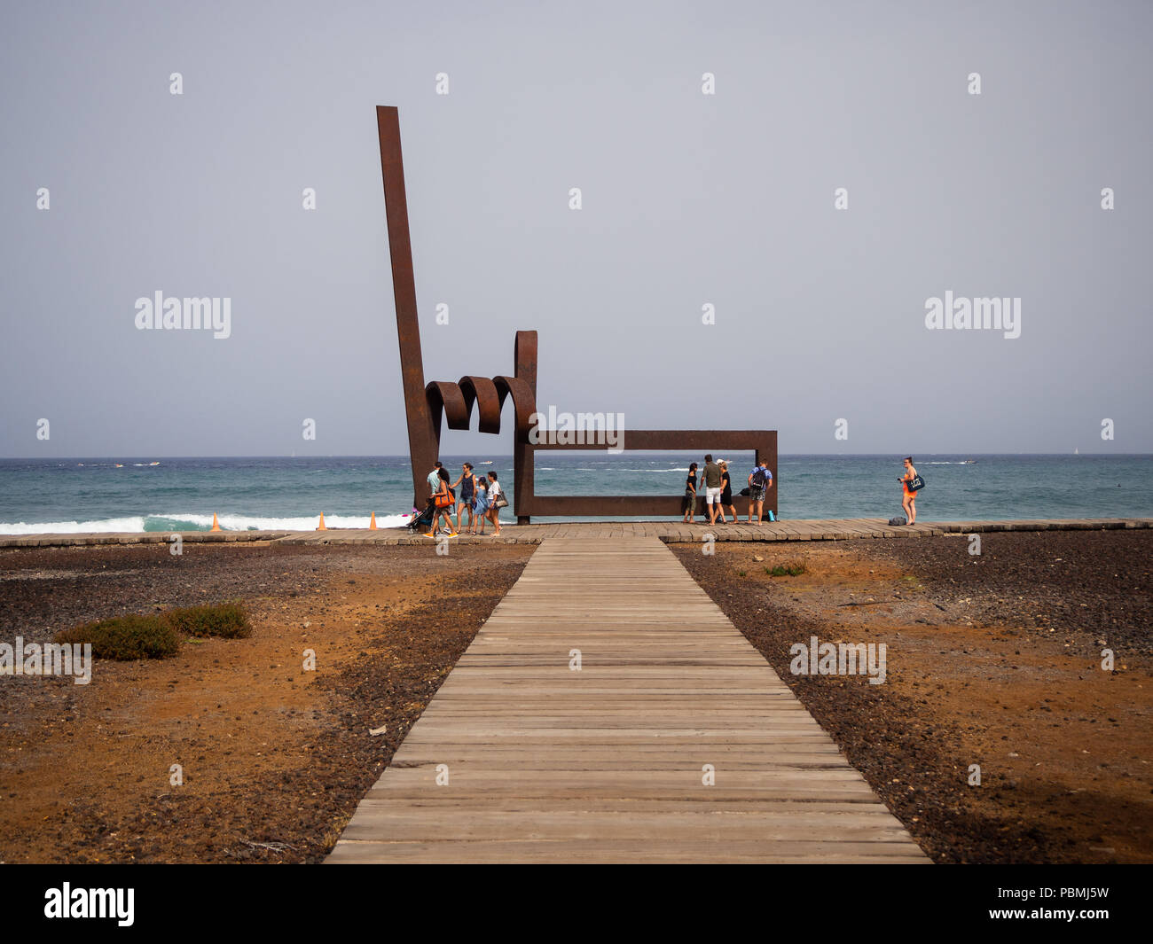Playa de Las Americas, Tenerife, Spagna - 11 Luglio 2018: Persone in appoggio o passando per il modernista scultura di ferro, di oggetti artistici in metallo per artista J.L. Salvad Foto Stock