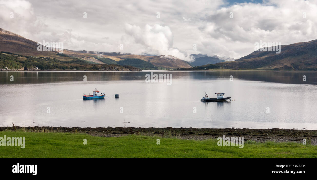 Barche da pesca sono ormeggiate in Loch Ginestra a Ullapool, sotto le montagne del nord-ovest Highlands della Scozia. Foto Stock