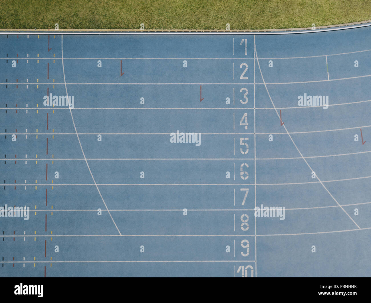 Vista aerea del traguardo di una pista di atletica leggera. Vista superiore del blu all-weather via di corsa in uno stadio. Foto Stock