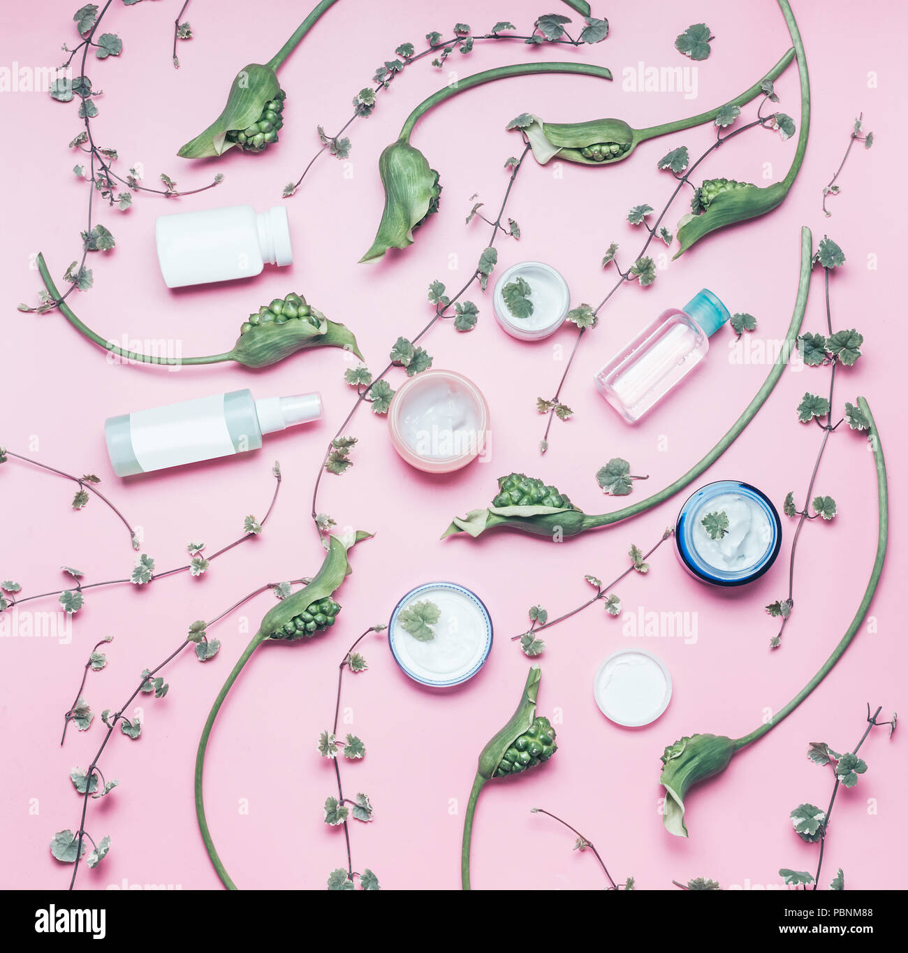 Cosmetici naturali e il concetto di bellezza. Lay piatto con vari prodotti cosmetici con spazio copia , verde fiori e foglie di rosa pastello, sfondo top Foto Stock
