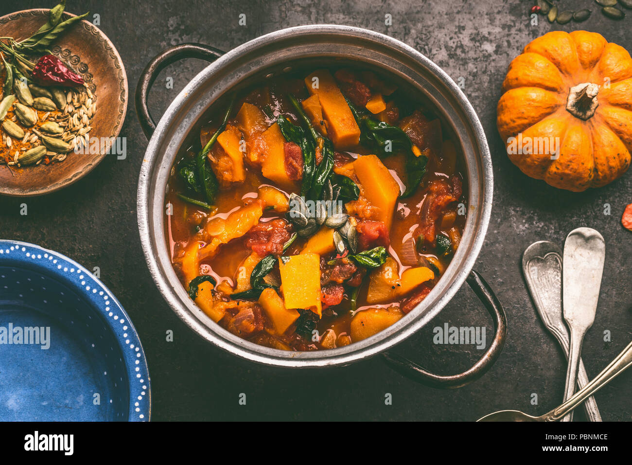 Chiusura del gustoso piatto di zucca in pentola di cottura sul buio cucina rustica sfondo tabella, vista dall'alto. Stufato di zucca. Autunno rustico stagionale country food Foto Stock